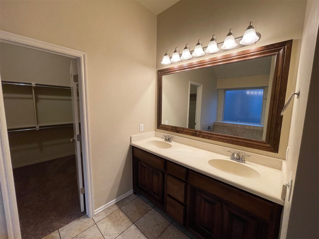 317 Durkee Road, Yukon, OK 73099 bathroom with tile floors, vanity with extensive cabinet space, and dual sinks