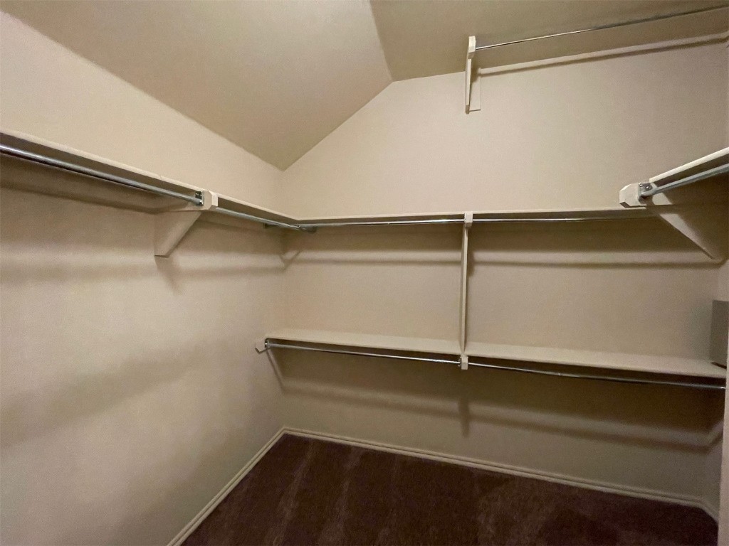 317 Durkee Road, Yukon, OK 73099 spacious closet featuring lofted ceiling and dark carpet