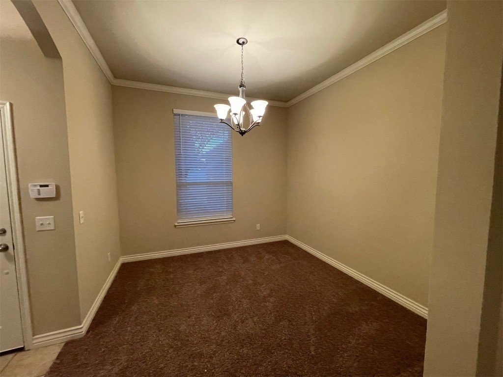 317 Durkee Road, Yukon, OK 73099 empty room with carpet floors and a chandelier