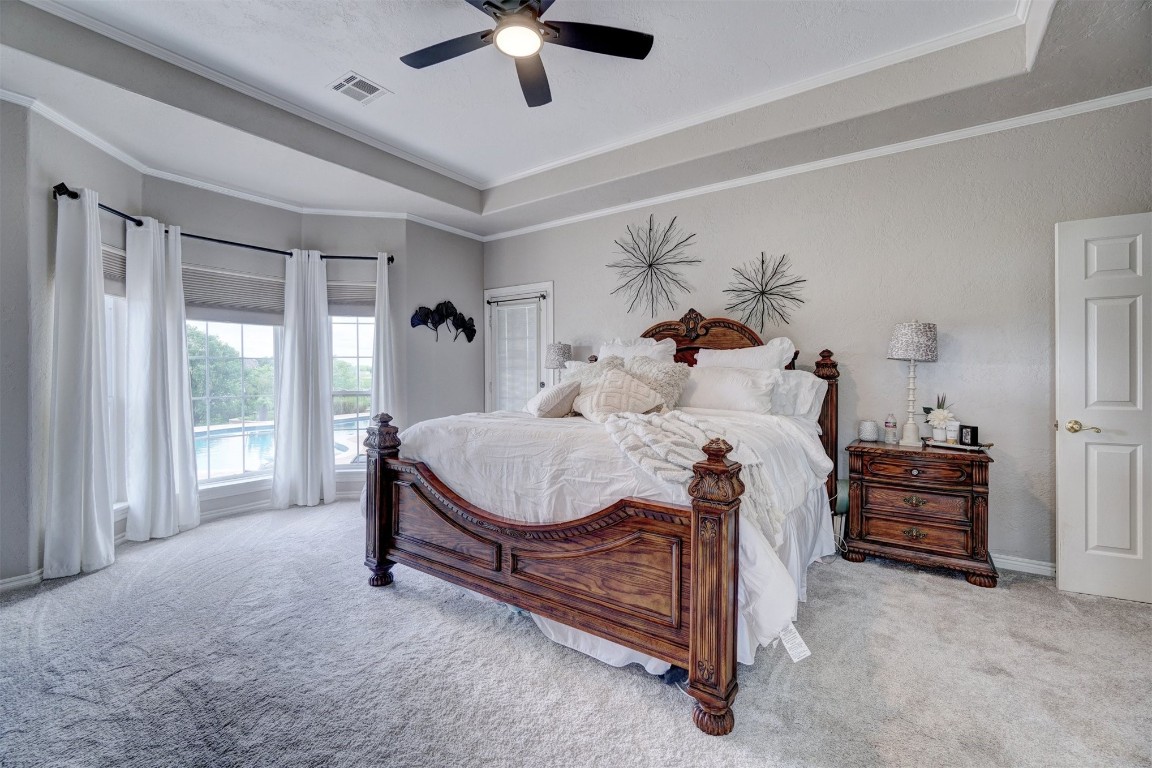 1918 Tyler Terrace, Prague, OK 74864 bedroom featuring ceiling fan, carpet, crown molding, and a tray ceiling