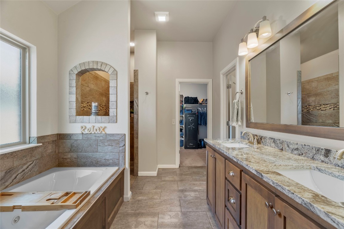 10821 NW 29TH Terrace, Yukon, OK 73099 bathroom featuring double sink vanity, a bathtub, and tile flooring