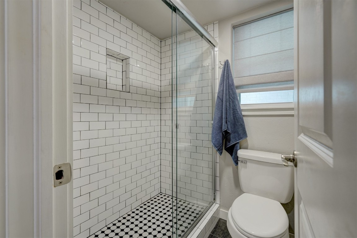 10112 Midfield Cross Street, Oklahoma City, OK 73159 bathroom featuring a shower with shower door, toilet, and tile flooring