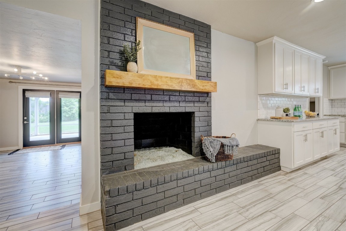 10112 Midfield Cross Street, Oklahoma City, OK 73159 living room featuring light hardwood / wood-style flooring, brick wall, and a brick fireplace