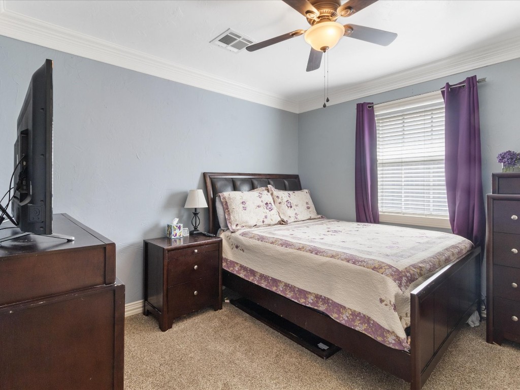 4935 SE 54th Street, Oklahoma City, OK 73135 bedroom featuring light carpet, ceiling fan, and crown molding