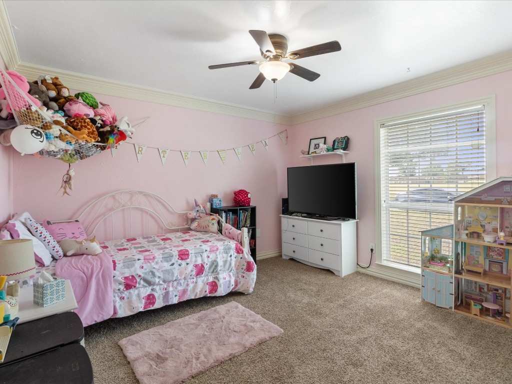 4935 SE 54th Street, Oklahoma City, OK 73135 bedroom with ornamental molding, multiple windows, carpet flooring, and ceiling fan