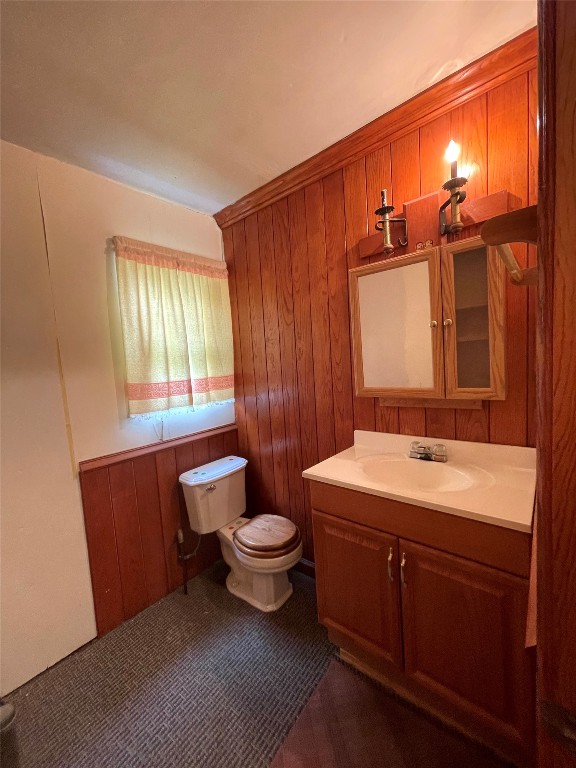 5324 S Agnew Avenue, Oklahoma City, OK 73119 bathroom featuring wood walls, vanity, and toilet