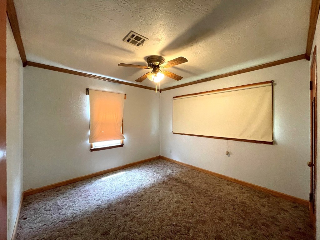5324 S Agnew Avenue, Oklahoma City, OK 73119 carpeted spare room featuring a textured ceiling, ceiling fan, and ornamental molding
