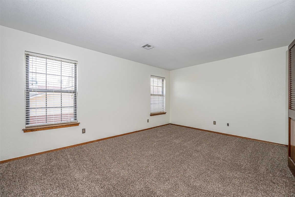 4400 Hemingway Drive, #242, Oklahoma City, OK 73118 empty room with a healthy amount of sunlight and carpet flooring