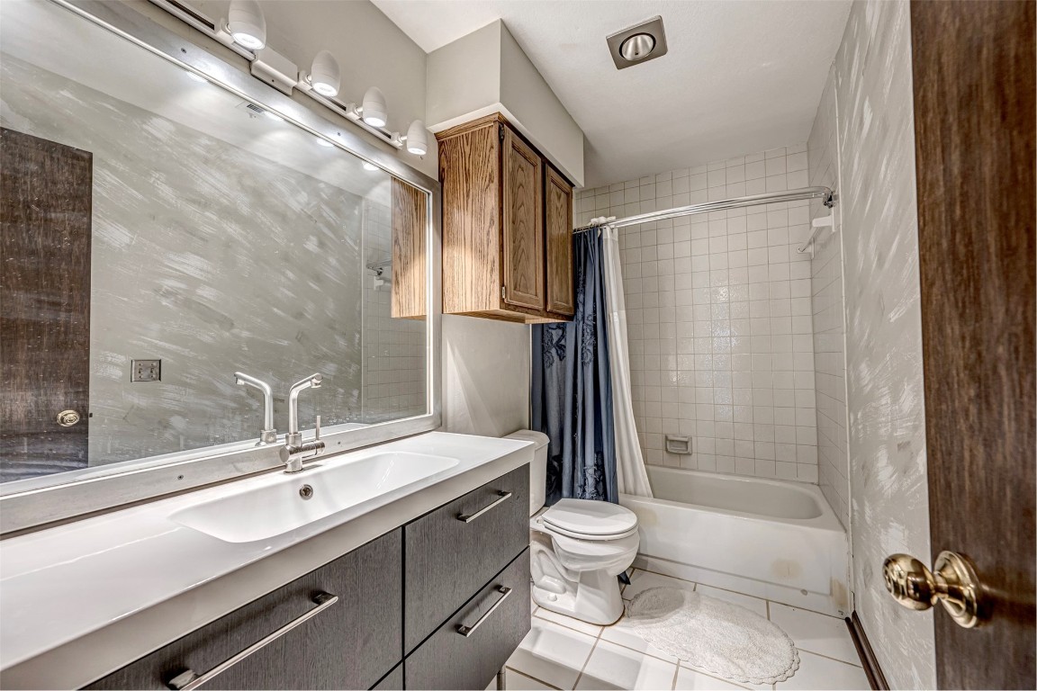 4400 Hemingway Drive, #242, Oklahoma City, OK 73118 full bathroom with tile flooring, oversized vanity, toilet, and shower / tub combo with curtain