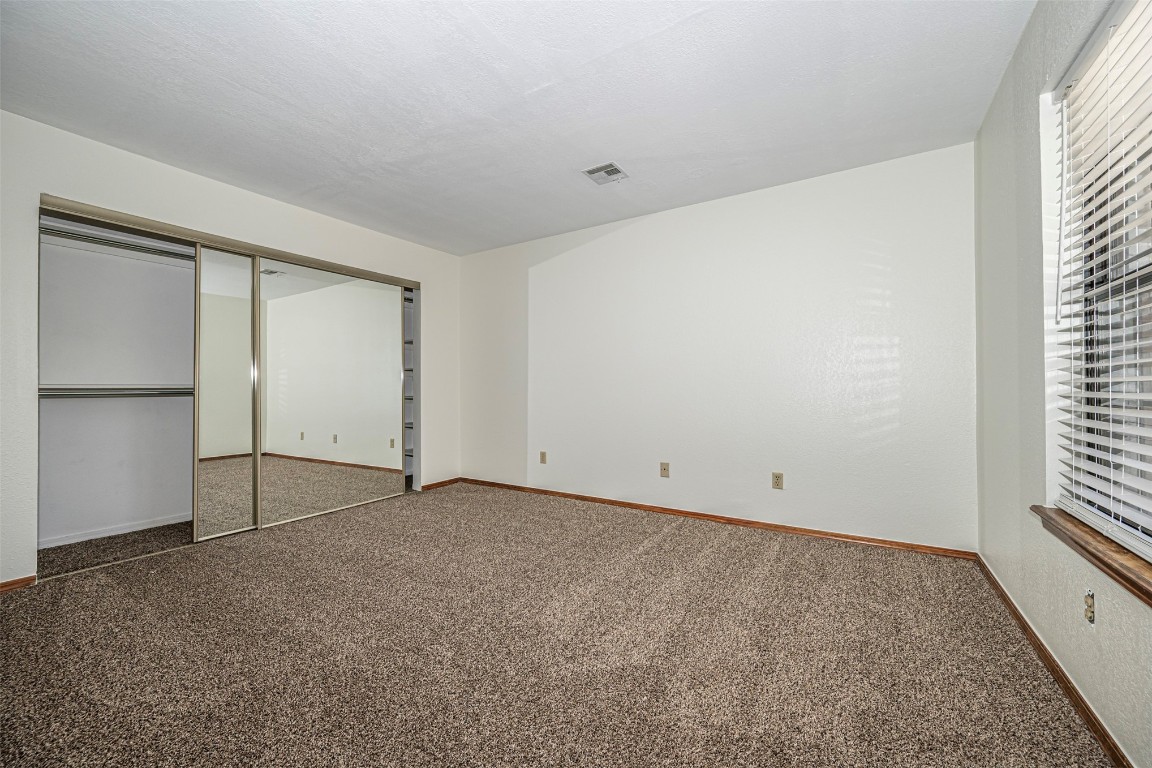 4400 Hemingway Drive, #242, Oklahoma City, OK 73118 unfurnished bedroom featuring carpet flooring and a closet