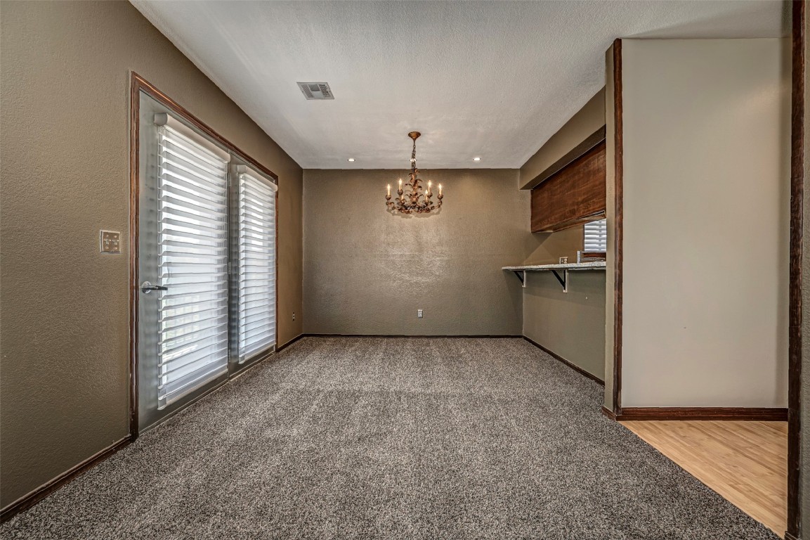 4400 Hemingway Drive, #242, Oklahoma City, OK 73118 empty room featuring carpet floors and an inviting chandelier