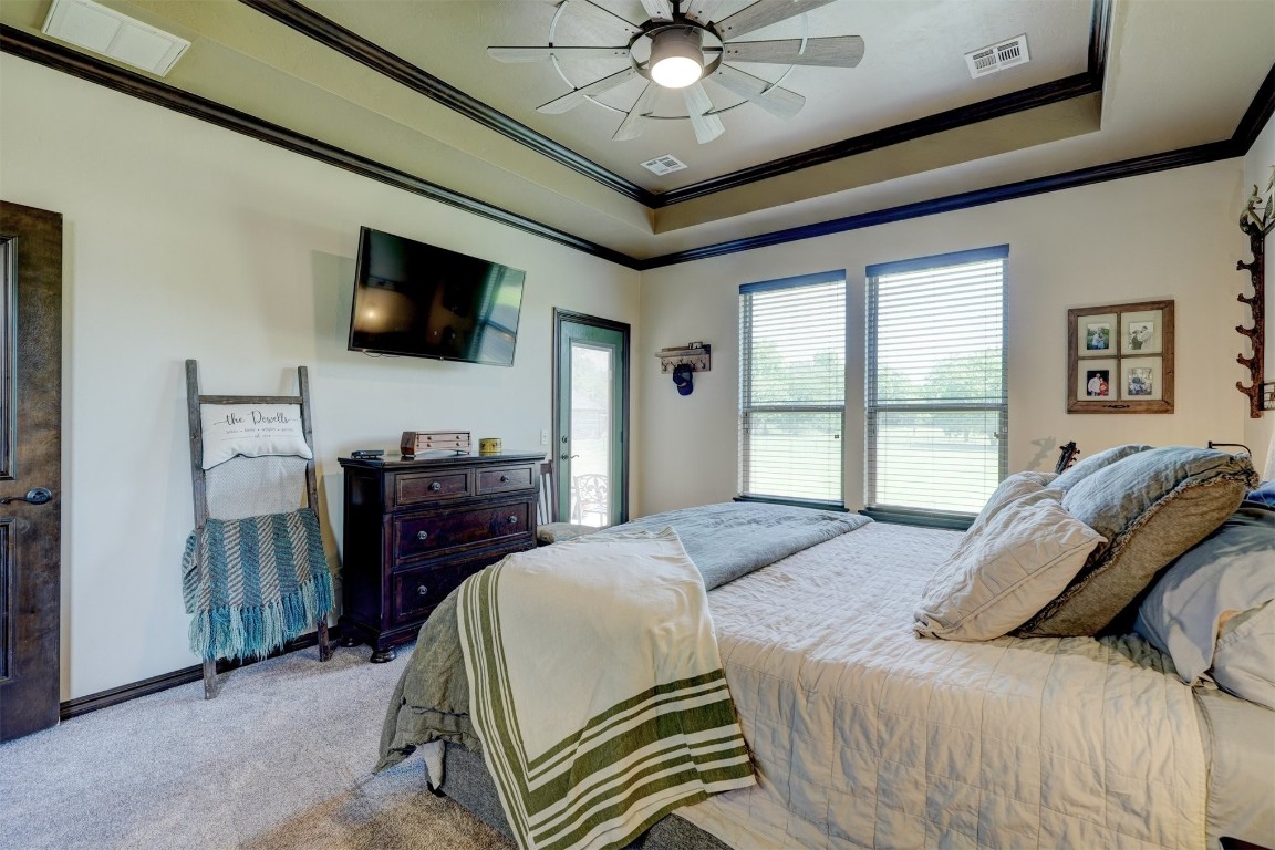 4422 Buffalo Hill, Guthrie, OK 73044 carpeted bedroom featuring a raised ceiling, ceiling fan, and crown molding