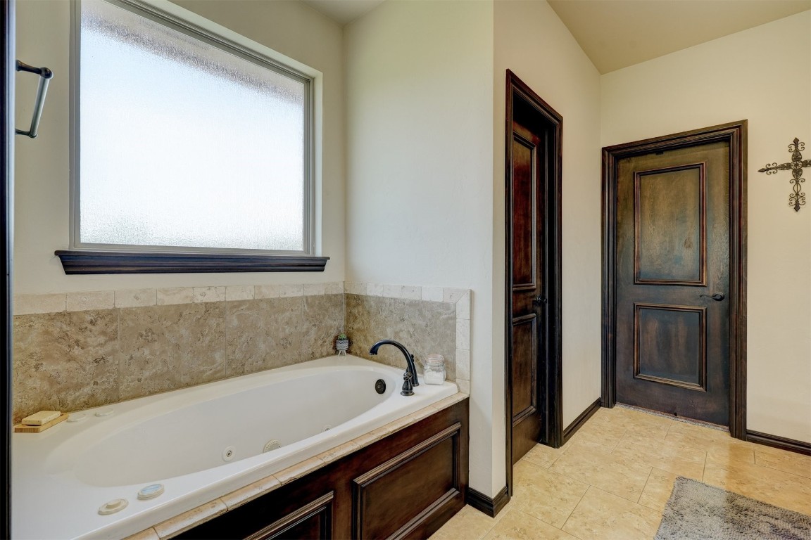 4422 Buffalo Hill, Guthrie, OK 73044 bathroom featuring a bathing tub, a healthy amount of sunlight, and tile floors