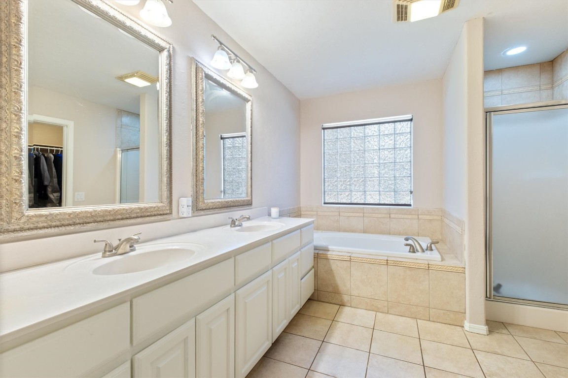 2340 S Rockwell Avenue, Newcastle, OK 73065 bathroom featuring double sink vanity, tile floors, and plus walk in shower