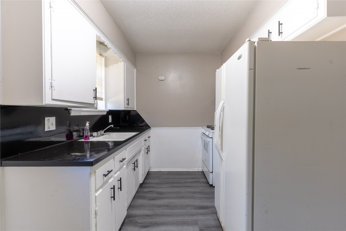 1600 Cynthia Drive, Oklahoma City, OK 73130 kitchen featuring sink, white appliances, white cabinets, and dark wood-type flooring