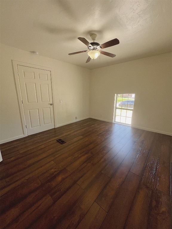 2721 Texoma Drive, Oklahoma City, OK 73119 empty room with dark wood-type flooring and ceiling fan
