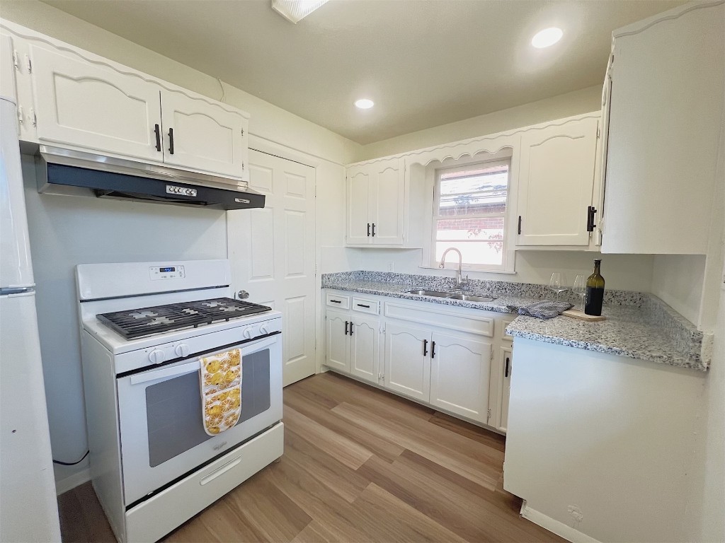 2721 Texoma Drive, Oklahoma City, OK 73119 kitchen featuring white cabinets, sink, white appliances, and light hardwood / wood-style floors