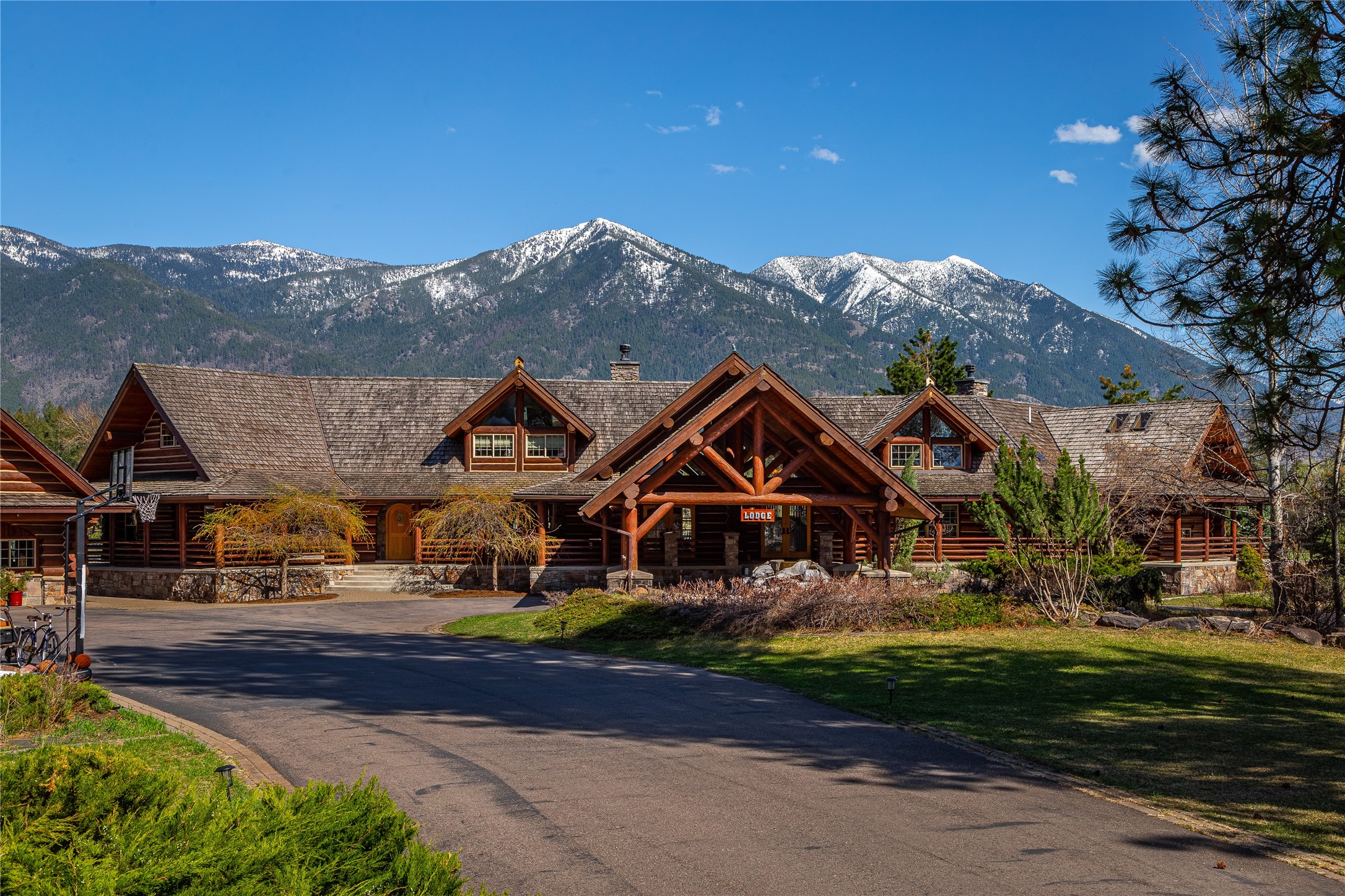 In the heart of the Flathead Valley find your sanctuary amidst 20 acres of towering pines with commanding views of the Columbia Mountains. The Lodge is a testament to craftsmanship spanning 7,000 sq ft, built of 18” hewn logs and stone, each detail a nod to the wild heart of Montana. This grand home is designed as a gathering space to bring together family and friends with 22’ ceilings, a large open concept kitchen, massive double sided river rock fireplace and a downstairs movie/game room. The property boasts three additional complimentary buildings, each with their own accommodations, this gives the ability to host large groups and adds to the value of this prized estate. Take in nature, local wildlife, the mountains and alpenglow all framed beautifully from the back deck evoking the notion this isn’t just land, it’s a Montana legacy. The property is unzoned, inviting your dreams! The Feature Sheet is a must see. Call Sonja Burgard 406.871.0372 or your real estate professional today. See Floor Plans under "Documents"
Offered fully furnished minus small seller exculsion list.