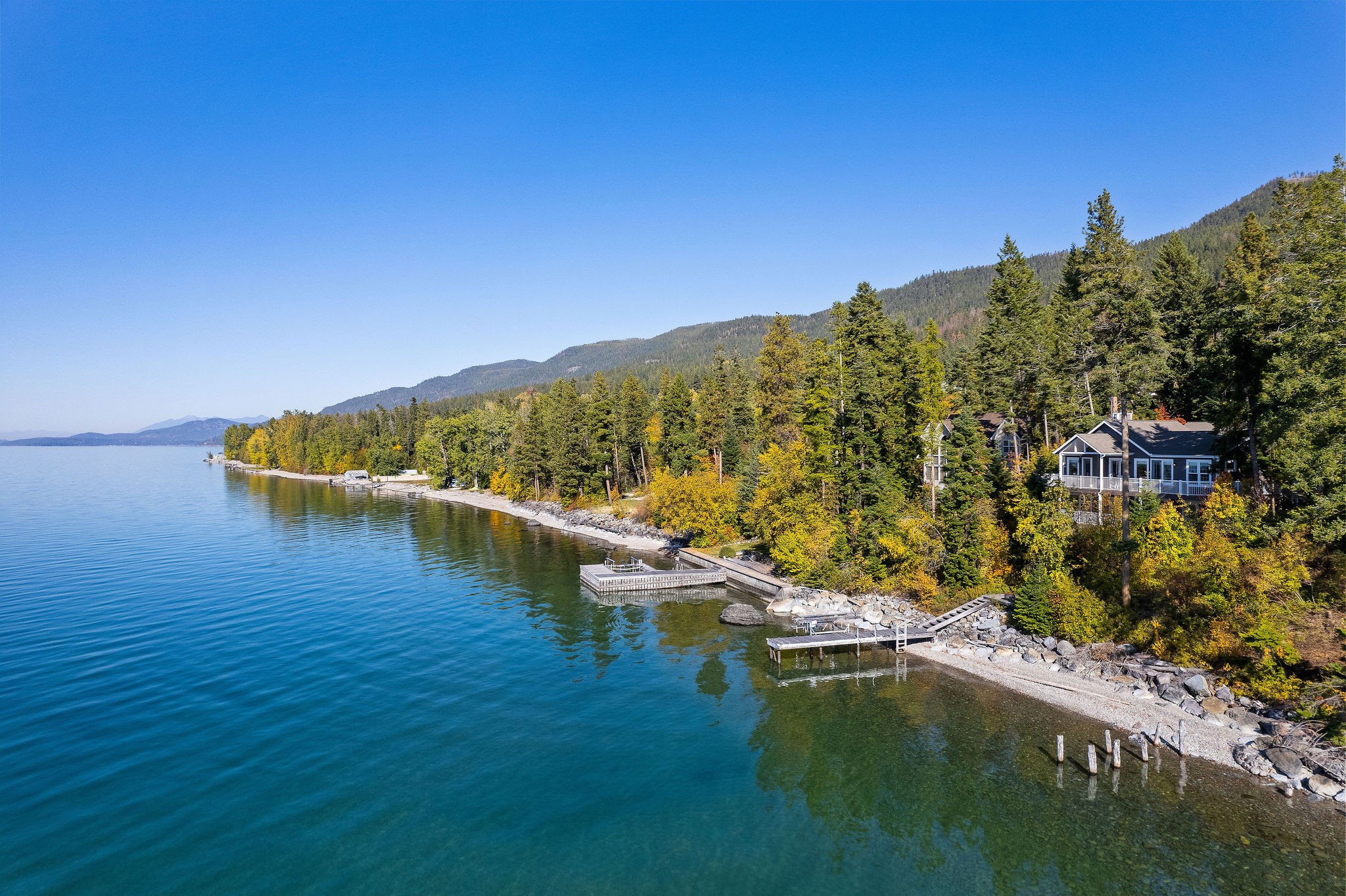 Welcome to this lakefront paradise boasting 100' of prime Flathead Lake frontage and 180 degree Flathead Lake views! This stunning 3BD/3BA custom home boasts no HOA or CCRs & provides you with a 1.38 acre slice of Montana's natural beauty, including breathtaking sunset views over the lake! Enjoy the crystal-clear waters & the ease of lakefront living w/ your own dock & lift station. This spacious 2,635 SF home features high-end custom finishes including granite countertops & knotty alder custom cabinets, doors, & trim; a private elevator, & an ADA-compliant lower-level bathroom. The lot provides ample space for outdoor activities, gatherings, additional structures, and RV parking. Don't miss this opportunity to own a lakeside retreat w/ all the modern comforts you desire. Minutes to downtown Bigfork! See Feature Sheet in docs. Swan Lake, Glacier National Park, Whitefish Resort, and Jewel Basin Hiking area nearby. Call Jennifer Shelley at 406.249.8929, or your real estate professional.
