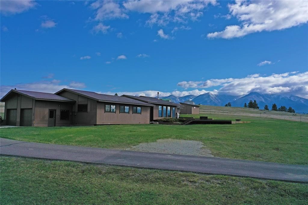 Panoramic mountain views, sunrises across the hay fields & walks to the shores of Lake Koocanusa. This home is situated on 20 acres surrounded by endless recreation w/ another 20 for sale right next door. Elevated among the rolling hills, it boasts a sprawling & open floor plan, w/ large windows & skylights that fill the home w/ natural light all year long. Oversized bedrooms & a functional layout make this a great space for entertaining or large groups. Upgrades include custom woodwork, steel framing, granite countertops, in-floor heat & cozy fireplaces in the family room & master. The wide-open bonus room was framed to be split into two rooms or left as one open space for gathering or a hobby room. An attached garage & paved drive make for easy winter parking. Additional multi-use outbuildings include wood sheds, a barn & a huge heated shop w/ natural light & insulated rooms that could easily be converted to guest quarters. Call Gretchen 406-291-7099 or your real estate professional.