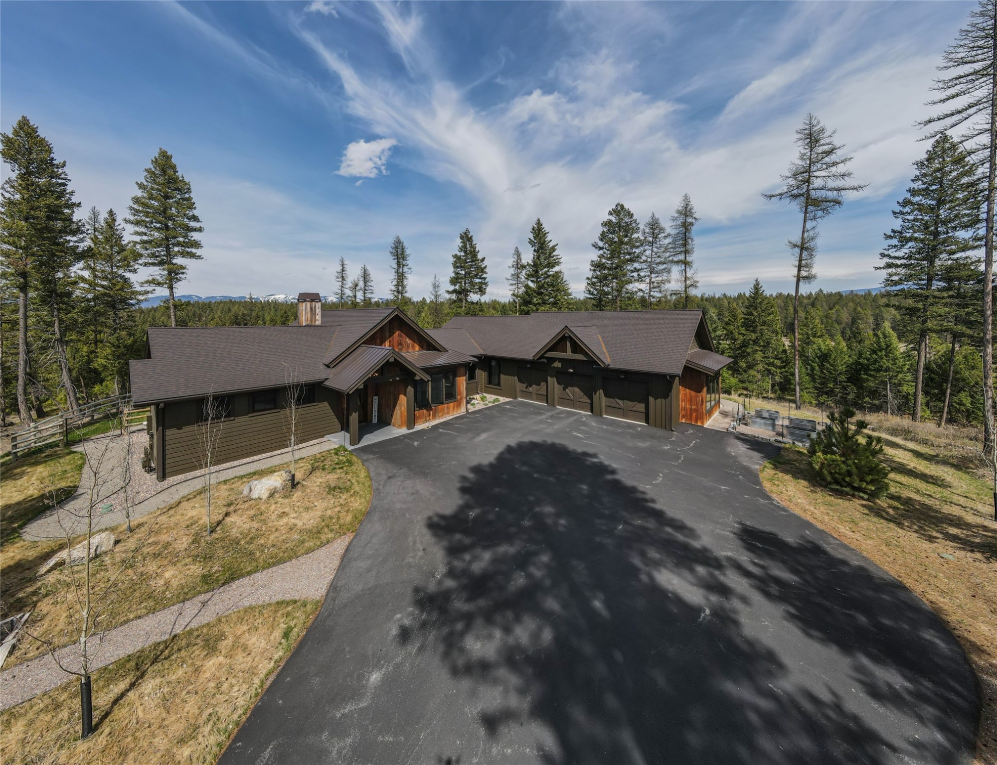 Discover your private haven in Whitefish, MT – a captivating 4-bed, 3-bath mountain modern farmhouse on 6.7 acres. With 2,755 SF of thoughtfully designed living space, you'll admire the 12' & 10' ceilings, wood floors, and a cozy wood fireplace in living room overlooking awe-inspiring mountain views. The gourmet kitchen, adorned with granite and quartz countertops, and a butler's pantry, is a culinary enthusiast's dream. The master suite boasts heated bathroom floors, large walk-in closet, and floor-to-ceiling glass, with sliding doors leading to an outdoor patio. Additional dual master suite is perfect for guests. Outside, the fenced backyard, fire pit, heated outdoor patio, and built in BBQ kitchenette invite you to embrace Montana's outdoor lifestyle. The 3-car heated garage ensures both storage and convenience, home also has a fenced garden area. Set against a backdrop of breathtaking natural beauty, this property isn't just a home – it's a retreat from the ordinary!