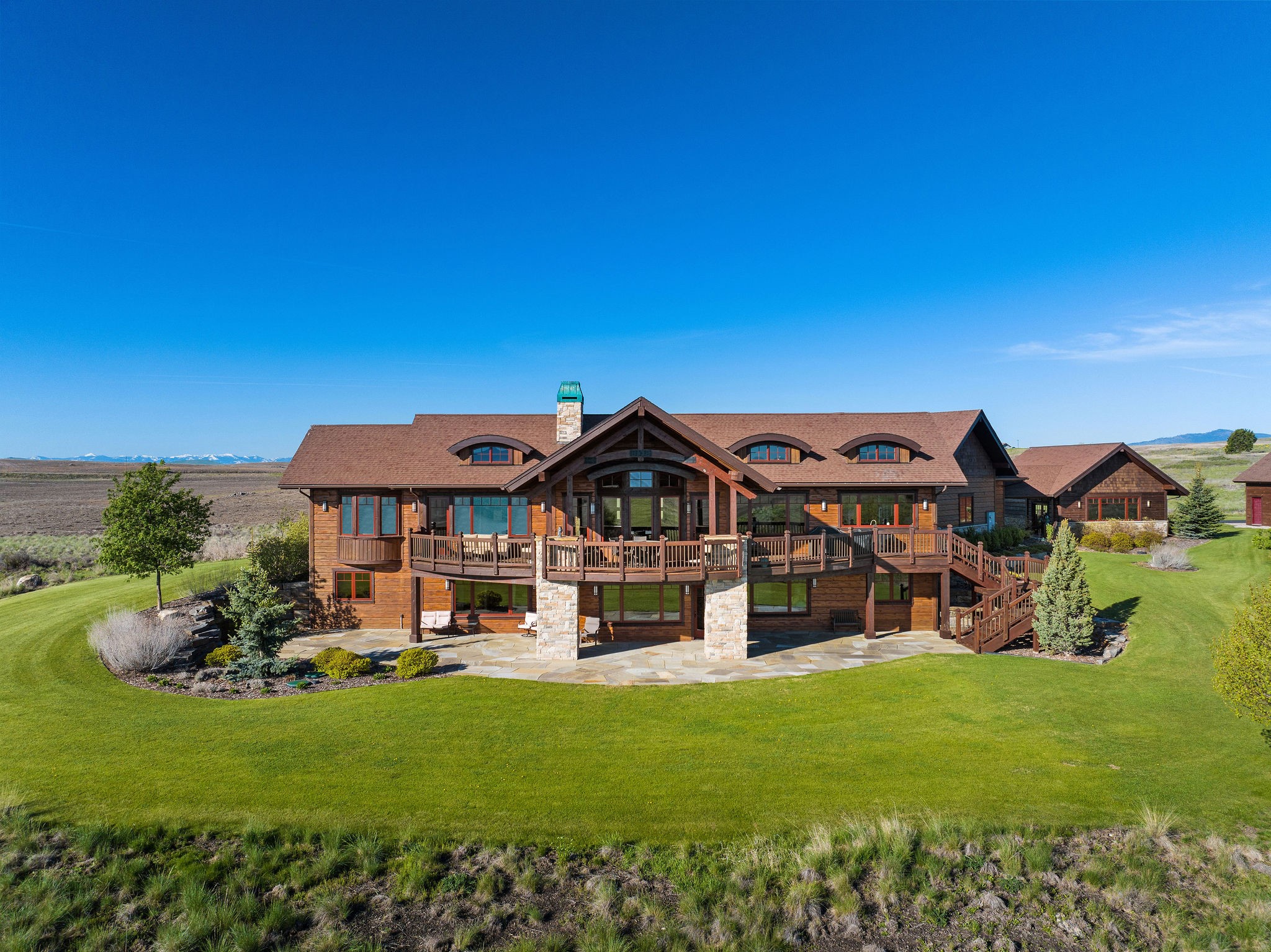 Exquisite custom craftsmanship meets spectacular Mission Mountain and Flathead Lake views at this 4BD/4BA 4,941 SF home on 10.03 acres. With a main level primary suite, this home showcases a gorgeous fusion of woodwork and upscale finishes, which include natural hickory wood and travertine tile floor, hand-picked Chief Cliff Rock on both interior fire places and exterior columns, knotty alder doors & trim, granite countertops, T&G pine ceiling, lower-level in-floor radiant heat, and handblown glass lighting from Hubbardton Forge. Step outside the main level to the covered deck, or the lower-level walkout to the covered patio for endless entertainment possibilities. Walk through the covered breezeway to access the 30x24 heated shop, while a 30x40 barn, added in 2020, further enhances the property’s functionality.  Flathead Lake recreation and amenities are just minutes away! See Feature Sheet in docs. Call Jennifer Shelley at 406.249.8929 or your real estate professional.