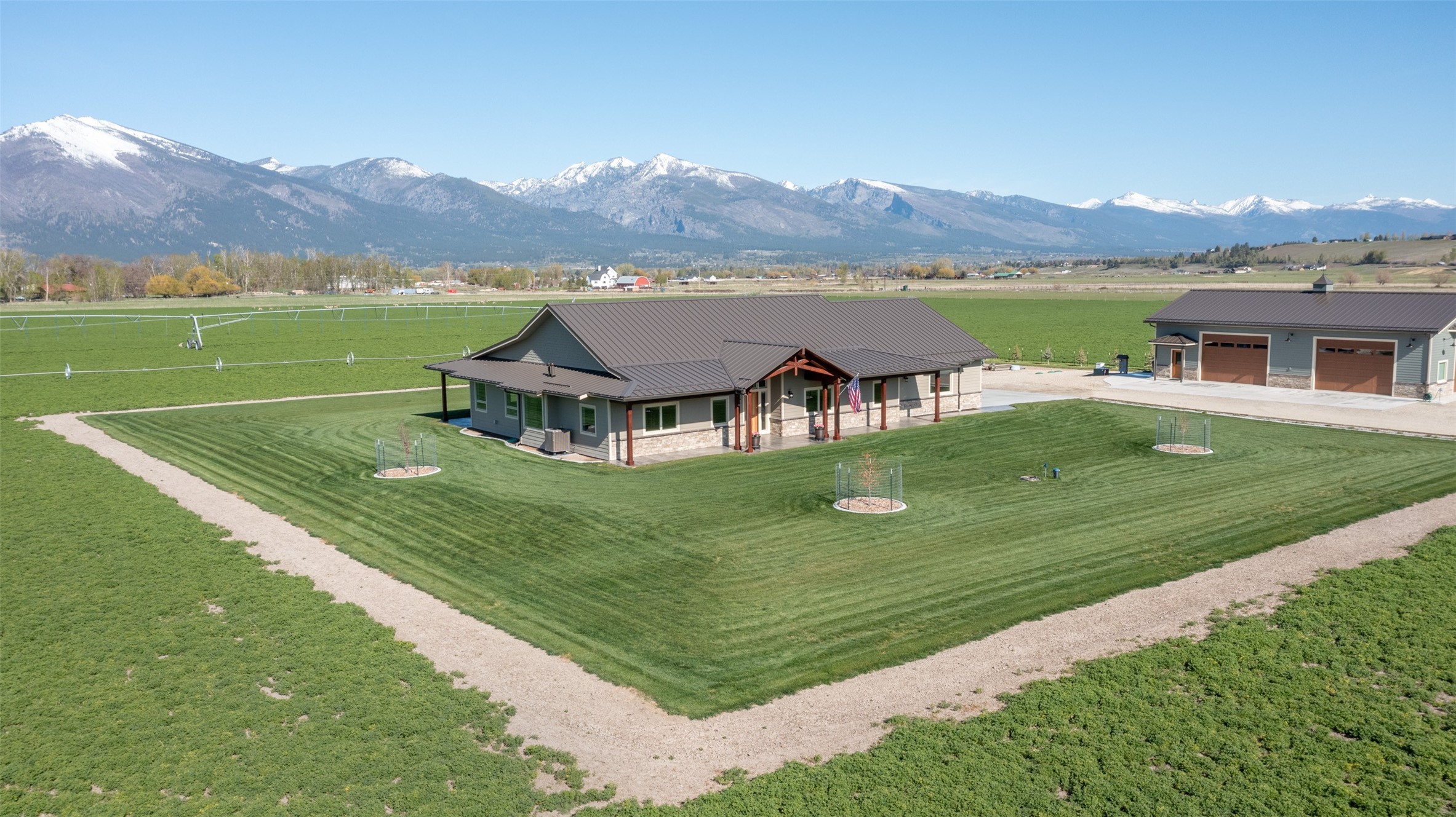 Nestled on 39.11 acres on the east side of the picturesque Bitterroot Valley, 535 Fish Hatchery in Hamilton, MT, offers an unparalleled living experience with breathtaking views of the Bitterroot Mountain Range spanning 40 miles from north to south. Just 3.5 miles from Hamilton's Main Street, this property boasts a prime location, ensuring a perfect blend of serenity and convenience, while also offering versatility with the ability for it to be subdivided. As you approach, a custom 2¼" Ribbon Sapele Mahogany front door welcomes you to a residence completed in September 2019, featuring 3 bedrooms and 2.5 bathrooms across 2,425 Sq. Ft. of meticulously designed living space. The attention to detail is evident throughout, from the reclaimed hardwood floors throughout the living area to the luxurious amenities in every corner. The kitchen is a chef's dream with granite countertops, Dacor appliances, a Kohler Whitehaven apron sink, and a Dacor wine refrigerator. The dining area is adorned with a custom 24" Tuscany alabaster pendant light, creating an elegant atmosphere for gatherings. The bedrooms offer comfort with Villanova Berber carpet, designer closets, and Casablanca Panama 54” ceiling fans. Bathrooms feature tile floors, granite countertops, and high-end fixtures, including a Kohler Stargaze 6’ freestanding tub in the owner’s suite. Energy efficiency is the key to this home. Designated by Bonneville Power Authority (BPA) and Ravalli Electrical Cooperative (REC) as an energy efficient “Montana House II”. The Sierra Pacific H3 windows and doors throughout the home provide stunning v360-degree views and exceptional energy efficiency, complemented by custom window blinds, 6” wide interior walls, and R-15 Roxul rock-wool insulation for enhanced interior sound damping. The property extends its charm to the exterior, showcasing Diamond Kote siding, stamped concrete patios, and a covered front porch to enjoy your morning coffee watching the sun rise or you can relax in the evenings under a covered back patio and watch the sun set over the Bitterroot Mountains.The 36x60 fully insulated shop, completed in November 2023, offers a versatile space with a full bathroom, Rinnai tankless water heater, Rinnai 35,000 BTU propane heater, 200-amp electrical capacity with 30 & 50-amp RV electrical outlet, in-floor drains, 26-gauge metal roof with 13’ ceiling. This structure includes three bays, making it a perfect complement to the main residence. For the agriculture enthusiast, the land is designated as "prime farmland" and "farmland of statewide importance" from the NRCS, supporting 74 AUMs. The land is classified as “grazing” and “Bonified Agriculture Land” with a tax rate of 2.16. An irrigation system, utilizing Reinke center pivot technology, ensures efficient water distribution to the 38 acres planted with Round-Up Ready Alfalfa offering 3 cuttings per year, equating to 4.5 tons per acre annually. Daily Ditches Irrigation District supplies the irrigation water that is fed to the Reinke center pivot, 638 feet long with 4 towers. The turbine pump is a Gould 25 HP - 410 GPM. 780 feet of wheel-line complements the center pivot. This irrigation system is stand alone and not shared with any other neighbors. With 93 Colorado Blue Spruce trees, a sprawling lawn, and a 2,400 Sq. Ft. enclosed garden, this property offers a harmonious blend of luxury living and agricultural potential. This stunning property will truly deliver the epitome of Montana living.