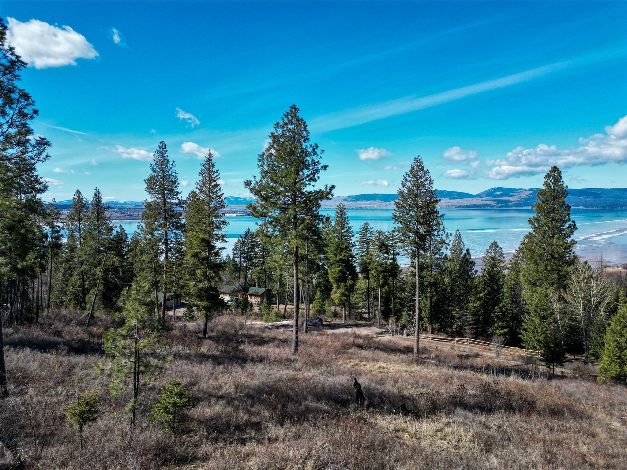 Introducing an amazing opportunity to own 5.1 acres of untouched beauty nestled along East Bay Lane in Polson, Montana. This parcel boasts panoramic vistas of the majestic Flathead Lake, with sweeping views overlooking Polson Bay. Situated minutes from Finley Point State Park which features a boat launch and offers a plethora of activities including boating, fishing, hiking, and picnicking, ensuring endless adventures for all ages. Despite its close proximity to Polson, a charming lakeside town offering modern conveniences and amenities, this property exudes a serene and secluded ambiance, providing the perfect retreat from the hustle and bustle of life. The land features several level areas, with diverse landscape, which includes multiple cleared and wooded areas ideal for constructing your dream home or vacation retreat. Electric infrastructure conveniently located next to the property line and corner pins have been marked, ensuring clarity regarding the property boundaries. Whether you envision building a year-round residence, a vacation getaway, or an investment property, this parcel presents limitless potential. Don't miss out on the chance to make your dreams a reality amidst the unparalleled beauty of Polson, Montana. Opportunity awaits! Contact Holly Naldrett at 406-407-2355 or your real estate professional.