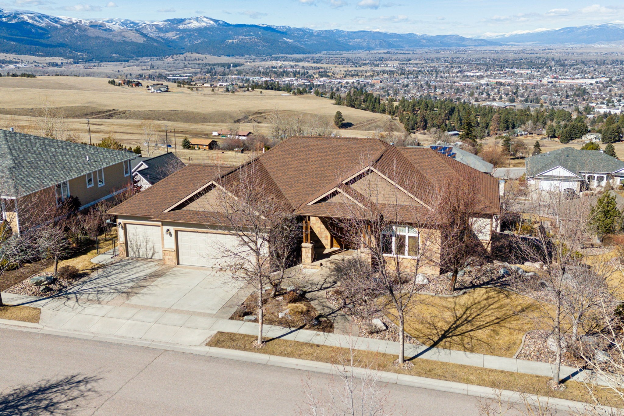 Experience a true luxury build in Mansion Heights, and the best views in Missoula. The main floor of 221 Mansion Heights Drive features a chef’s kitchen and dining space that overlooks the city. The stepped-down living room is perfect for socializing; or move the party outdoors to the sprawling wraparound deck. There are two main floor bedrooms; the owner's suite features a separate mini-split A/C for warm summer nights, a walk-in closet, and en-suite bathroom with radiant heated tile floors and a steam room. A spiral staircase leads you to the lower level, featuring an entertainment room with wet bar and an adjoining theater with (blackout curtains and audio system in place); two additional bedrooms, one currently converted into a home gym; and craft room with built-in peg boards. Beautifully landscaped yard and concrete patio on the lower level round-out the fine finishes in this luxury home. Lower level has been upgraded with brand new LVP flooring. The owners spared no expense on the internal systems of the home. Dual furnaces, dual water heaters, central A/C, mini-split A/C, central vacuum and leased water softener. Home is wired throughout with speakers (sound system/equipment included in sale). The three car garage also comes with built-in storage cabinets. Schedule a showing today. Call Warren Altounian at 406 550-2065, or your real estate professional.