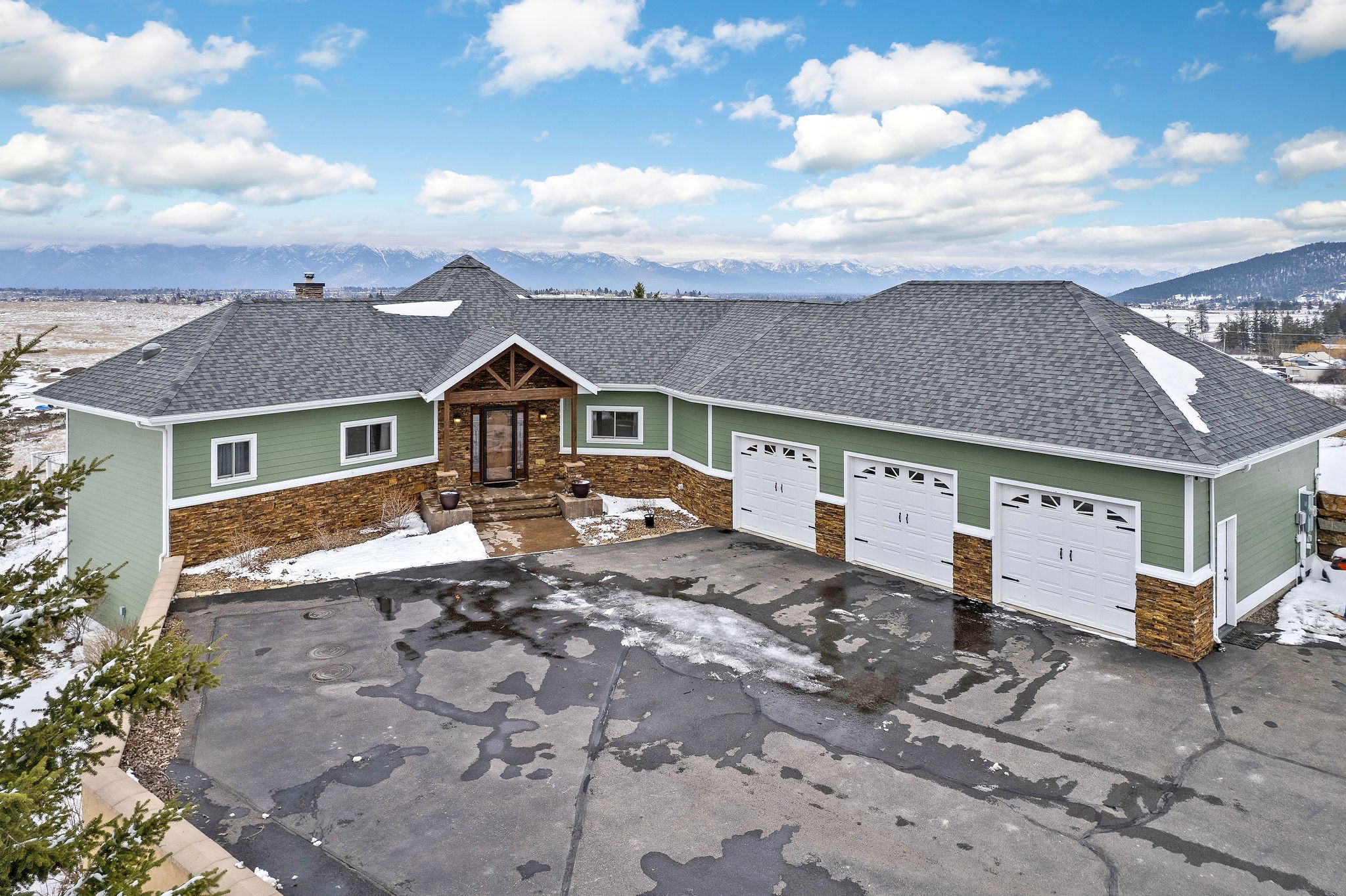 Located in the serene Ashley Hills with panoramic views stretching from Whitefish Mountain to Glacier National Park, Columbia Mountain, and the Swan Range. This captivating 3-bedroom, 3-bathroom ranch-style home, built in 2006, sprawls across 4,056 square feet on a generous 1.65-acre lot. The heart of the home is a stunning kitchen with hickory cabinets, under cabinet lights, and a water treatment system. The living room, bathed in natural light from large windows, features ambiance lighting and a unique rock gas fireplace that seamlessly connects to the primary bedroom. This bedroom is a true retreat, boasting a sliding door to the deck, a minisplit for perfect climate control, an ensuite with double vanity, jacuzzi tub, skylights, and a spacious walk-in closet. The house's interior is further enhanced by radiant heat with 9 zones, creating a comfortable environment throughout, and tile flooring that combines elegance with ease of maintenance. The property also includes a large entertainment room in the walk-out basement, complete with a wood stove and new carpet. Practicality is not overlooked, with a pristine utility room, washer and dryer hookups in the basement, and ample storage options, including large double closets in the basement bedroom. This home is wired with speakers throughout, ensuring entertainment and ambiance in every room. Outdoor living is equally impressive, with a covered patio featuring natural gas hookups for a grill, a wraparound Trex deck, a 7x7 storage shed, and RV parking with power hookups. 3 stall garage with 220 electrical, radiant floor heat with drain, A/C, and a utility sink, making it more than just a parking space. Important updates include a new boiler and hot water heater, exterior painted in 2021, and a sump pump in the basement for peace of mind. This home is just 5 minutes from Kalispell’s amenities and close to all the outdoor adventure opportunities that Montana has to offer. Call Kara Chapman (406) 407-7509 or your Real Estate Professional.