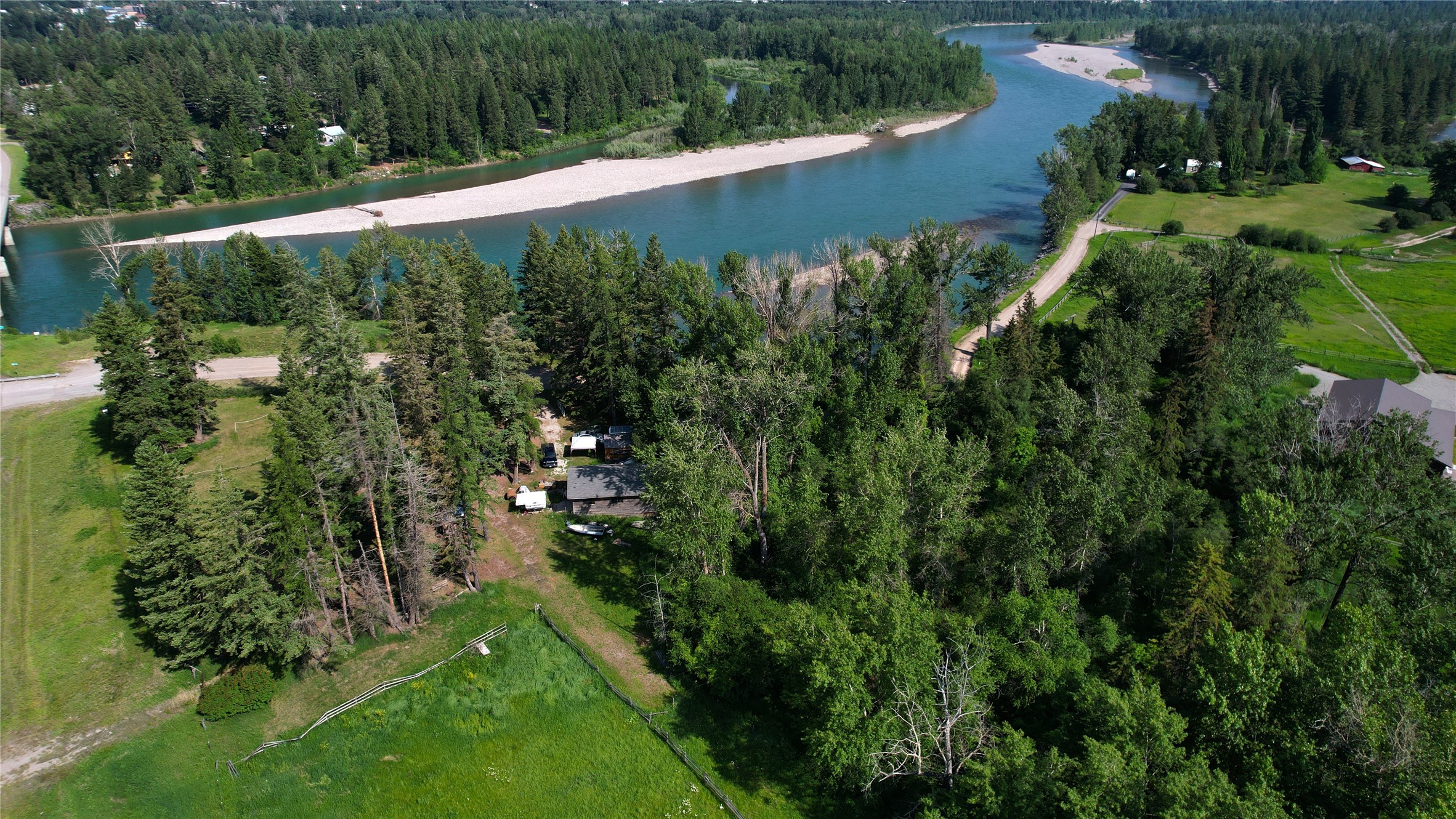 A rare opportunity with over 500 feet of prime Flathead River frontage. Having the ability to go down to the river and fish adds a whole new dimension to the properties appeal. With 12+ acres there's plenty of space to create your dream hobby farm with vegetable gardens, chickens, rabbits, goats, and horses. Let your imagination run wild  Drop your kayak, paddle board, or fish from the shore. Just minutes from Columbia Falls with panoramic and breathtaking views of Glacier Park and Swan Mountain Range. Landscaped with rock outcroppings and flower beds. The partially finished detached two level shop is heated with a wood burning fireplace. Included is a tack room space, hay storage, and workroom area. Having 1,300 feet of Hwy 2 frontage adds convenience and accessibility. Please call Jeannie DeCarlo at 406.471.8546 or your real estate professional.