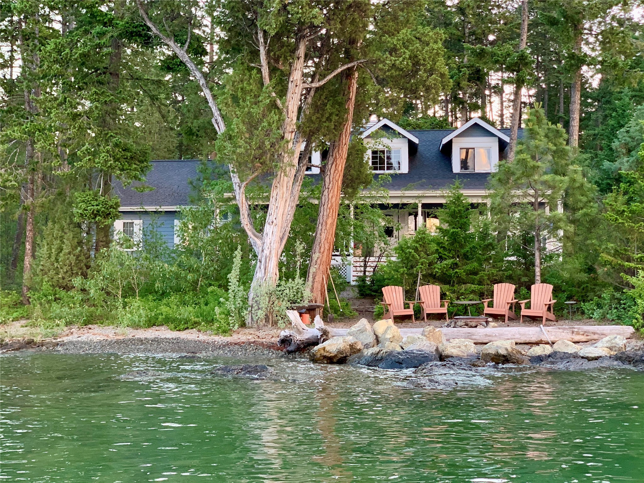 Experience the epitome of lakeside living at this picturesque Cape Cod style retreat, nestled on the tip of Caroline Point on the north side of Lakeside, Montana. 
Boasting 4 bedrooms and 2 bathrooms, along with an adorable sleeping cabin complete with a half bath, this well-appointed property also includes a garage for added convenience. Built in 1991 this home features breathtaking views of the lake and surrounding mountains, and a covered porch to host your dinners for family and friends.
Step outside onto the 175 feet of wraparound beachfront, complete with a private dock and boat lift, where you can indulge in a myriad of water sports or simply relax and take in the awe-inspiring scenery. 
Despite its secluded ambiance, this property is just a stone's throw away from the charming town of Lakeside, where you can enjoy dining, shopping, and a vibrant lakeside community atmosphere.  Contact Kelly Kennedy at 406-253-1203 or your real estate professional.