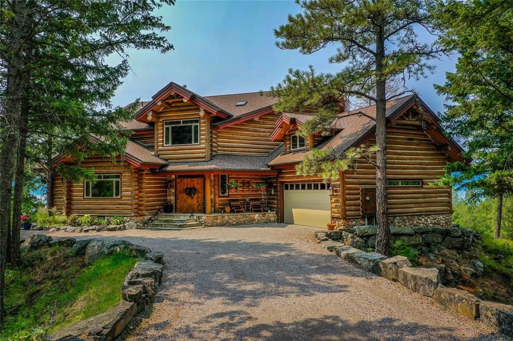 Embrace Montana's rustic luxury with this exemplary log home featuring 7 forested acres & awe-inspiring views of Flathead Lake. This residence is meticulously designed for hospitality, welcoming guests in comfort with 3 ensuite bedrooms & an open-concept kitchen & living area that serve as the heart of the home. Discover added versatility in the bonus room, currently utilized as a bedroom complete with two large closets, adjoining the master suite—a space ripe with potential for customization to suit your unique vision. Enjoy multiple alfresco seating options, fire pits, & hot tub. Explore the private walking trails carved throughout your own expanse of wilderness, or venture mere minutes to Bigfork for an evening of fine dining, shopping, & theater. The joys of snow sports beckon from Whitefish, less than an hour's drive, while Flathead Lake's recreational opportunities are just minutes away. For more information contact Kelly Rigg @ 406-382-9518 or your real estate professional. New Deck - Short Term Rent - No Covenants - Can Add Structures - Can Come Furnished

This property stands independently from any homeowners' association, presenting the rare opportunity to short-term rent and to build additional structures.

This residence is available fully furnished (minus a short exceptions list), offering a turnkey solution to immediately immerse yourself in the Montana lifestyle or seamlessly begin your short term rental.

Recent enhancements to this remarkable property include a brand-new deck, a completely remodeled master bathroom, and the addition of elegant wood flooring upstairs. These updates complement the installation of multiple fire pits and the meticulous crafting of walking trails for your enjoyment.

Any additional structures or short-term rentals must adhere to Flathead County guidelines.

Property boundaries shown are for illustrative purposes only and should not be considered accurate or legally binding.