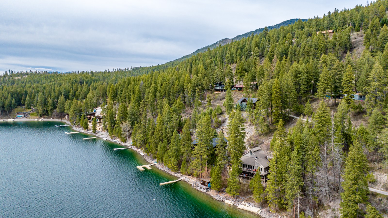 Whitefish Lake! Perched on the shores of Whitefish Lake on just over half an acre and providing unrivaled, serene Whitefish Lake and mountain views. This 4-bedroom + office, 2-bathroom, cozy lakeside cabin is offered fully furnished and turnkey, where comfort and luxury meet with warm natural light spilling into nearly every corner. 103 feet of PRIME, unspoiled Whitefish Lake frontage, and a private dock gift you with endless days of boating, swimming, and watersports right from your doorstep. The extensive and gorgeous outdoor living space was made for al fresco dining, lounging, and soaking up the perfect Montana summers. Enjoy all of what Whitefish has to offer, where 4 seasons of recreation await. Experience the epitome of lakeside living! Call Matt Buckmaster (406)261-8350 or your real estate professional for more information.