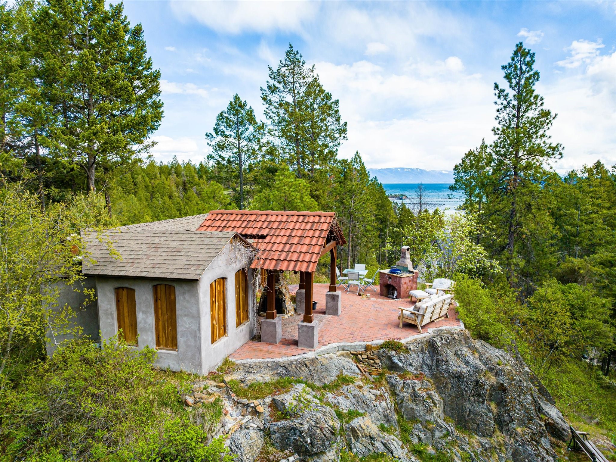 This remarkable property boasts stunning views of Flathead Lake and offers an extremely lush oversized landscaped yard where you will discover several tranquil garden nooks. Experience the enjoyment and ambiance of the enchanting Pizza Grotto placed up high on a rock plateau which features indoor-outdoor seating, & patio with multiple fireplaces, while admiring the gorgeous views of Somer's Bay. This property is a true gem! This large home offers separation of space and could possibly be used as a vacation rental. The bedrooms on the first story have an additional separate outside entrance. The second story features an airy kitchen & living room with wide open gorgeous views of the lake, a balcony, bedroom & 3/4 bath. Third floor is a large open great room with amazing views and another balcony. This very desired location is in close proximity to Somer's Boat Launch,& beach.  Please call Shelly Ragland (406) 261-5040 or Hamilton Ash (406)212-0381, or your real estate professional.