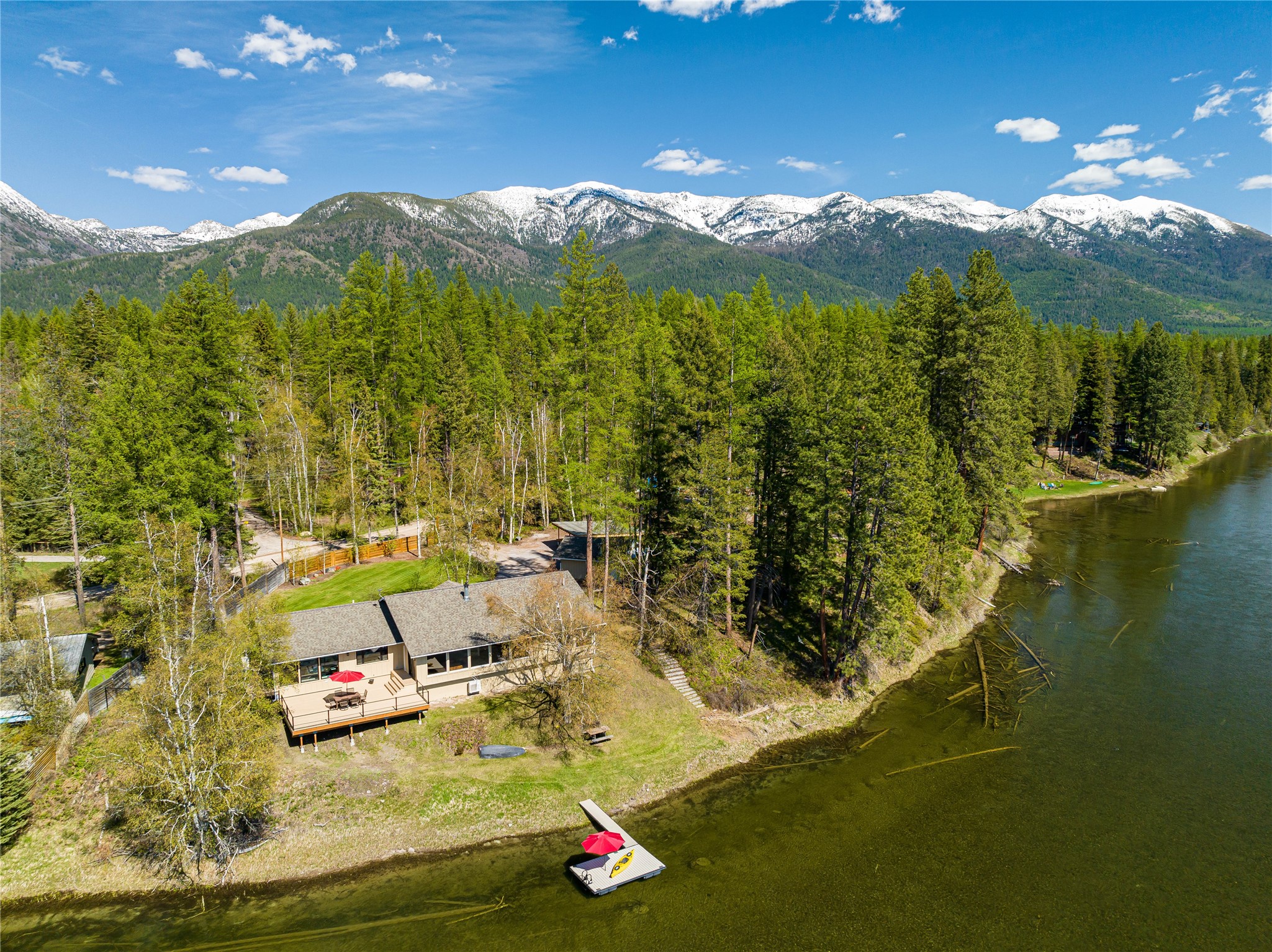 Riverfront property in Bigfork, Montana! Embrace the rhythm of the Swan River from your own private sanctuary. Single-level home whispers tales of Montana magic. With 293 feet of pristine waterfront with private boat dock, it's an invitation to cast off, paddle upstream, or simply marvel at the ever-changing river ballet from your expansive windows. Add a shop across the road . Two master suites offer luxurious retreats, while the new 600-square-foot waterfront deck becomes your stage for sunset celebrations and starlit reflections. New 22 kw back up propane generator and 2, 50 gallon water tanks. New doors and windows, heated flooring in master bath, walk in closet, mud room and laundry. Fenced for kids/pets with electronic security gate. No development can take place across the river.  
Listed by Bret Richmond.