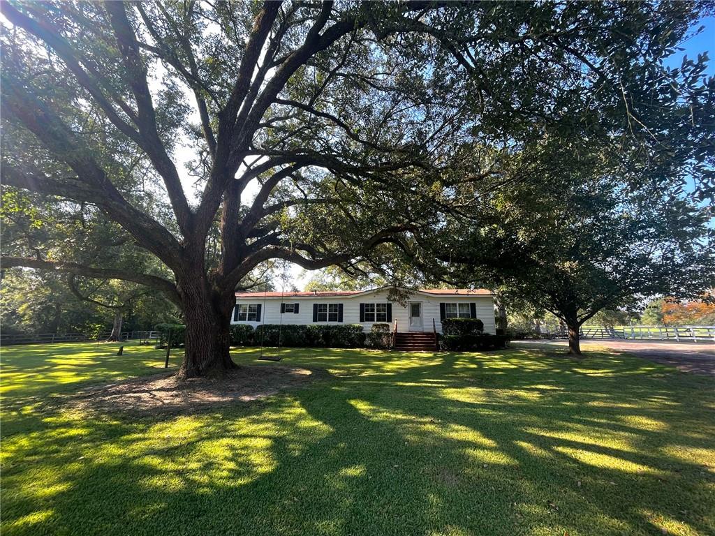 Bring your horses! Stunning 20-acre property featuring picturesque rolling hills and magnificent live oaks. This charming 3-bedroom, 2-bath double-wide mobile home comes fully furnished, has a spacious attached country porch, and a large 16x24 seperate recreation room. Perfect for a horse or cattle farm, the property includes two serene ponds, well-maintained fencing, and a 4-stall barn with a lean-to. Enjoy the breathtaking landscape and endless potential this exceptional property offers.