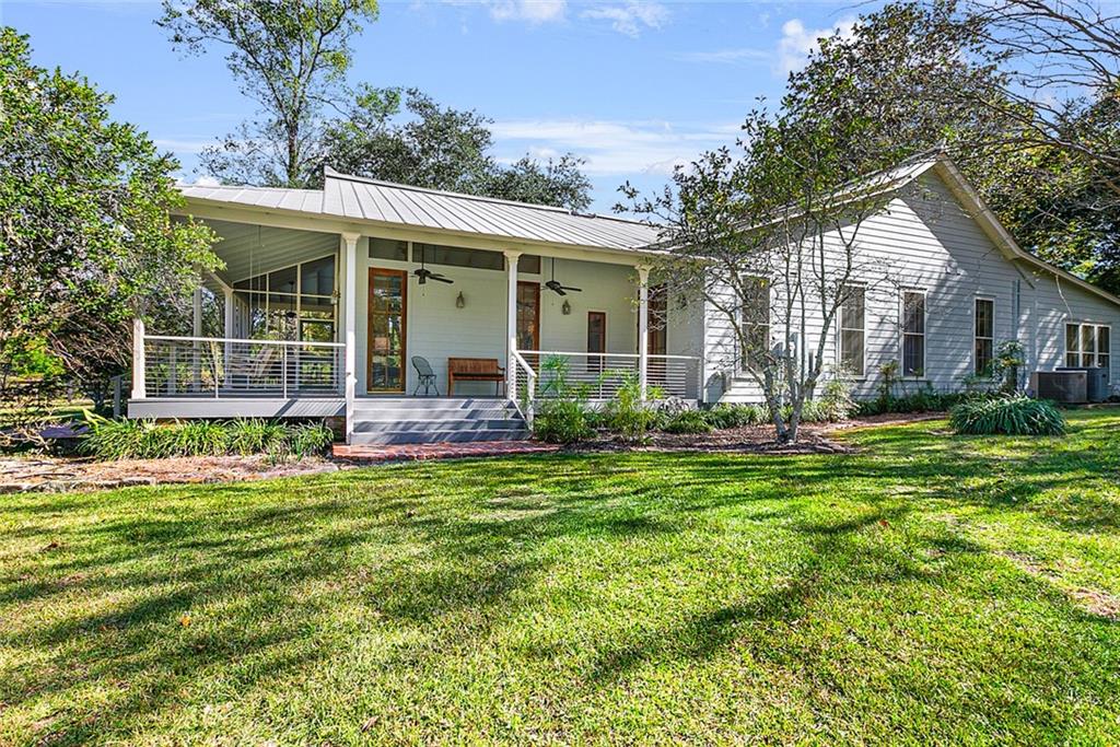 Pass through the gate, down the long, winding drive and you'll find a peaceful 9.5-acre retreat with a resurrected center hall farmhouse as the centerpiece. Just a few features of the grounds include a paddock, extensive vegetable garden as well as a serene pond with wooden bridge and gazebo for enjoying. The original 100-year old structure was taken down to the studs and carefully brought to back to life by meticulous owners who had an incredible eye for detail. The very special restoration blended historic charm and bountiful craftsmanship with guidance from renowned architect Richard Caldwell. From the quarter sawn pine floors and custom cypress cabinets to the mahogany windows and reclaimed wood doors, so many elements echo a Louisiana vernacular. The main house offers 3 beds, 2 beautiful baths and a home office. You'll appreciate the huge storage area for farm equipment or personal tools and toys. Guest house contains a small kitchen and two bedrooms. Truly the perfect-sized estate, five minutes to the Giddy Up and only 15 minutes from downtown Covington. This special property must be seen to fully appreciate.