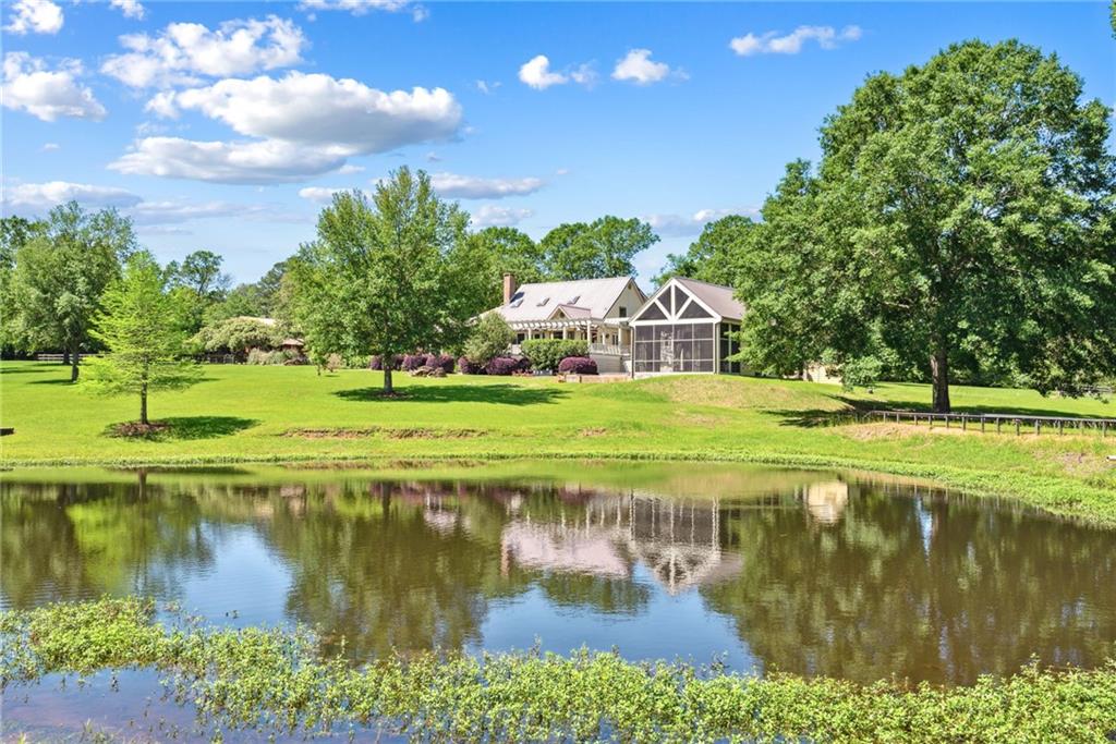 Stunning panoramic views abound on this picturesque retreat of 13 acres. Architecturally renovated and expanded, this remarkable estate offers a seamless blend of history and modern luxury. Step inside to discover a gourmet kitchen adorned with granite counters complemented by a spacious Butler's pantry. The master bath boasts travertine throughout, while an enormous sunroom and screened porches beckons for relaxation and entertainment. The addition of the pool house by Matt Voelkel with its full kitchen, bath, bunk room, office and entertaining areas all overlooking a heated saltwater infinity edge pool, a sparkling stocked pond and fenced acreage must be seen! Beyond the dwelling lies a haven of possibilities, featuring a whole house Generac generator, 6-stall pole barn, workshop, covered RV pad, and dual gated entrances. Experience the joys of country living combined with modern convenience in this extraordinary property.