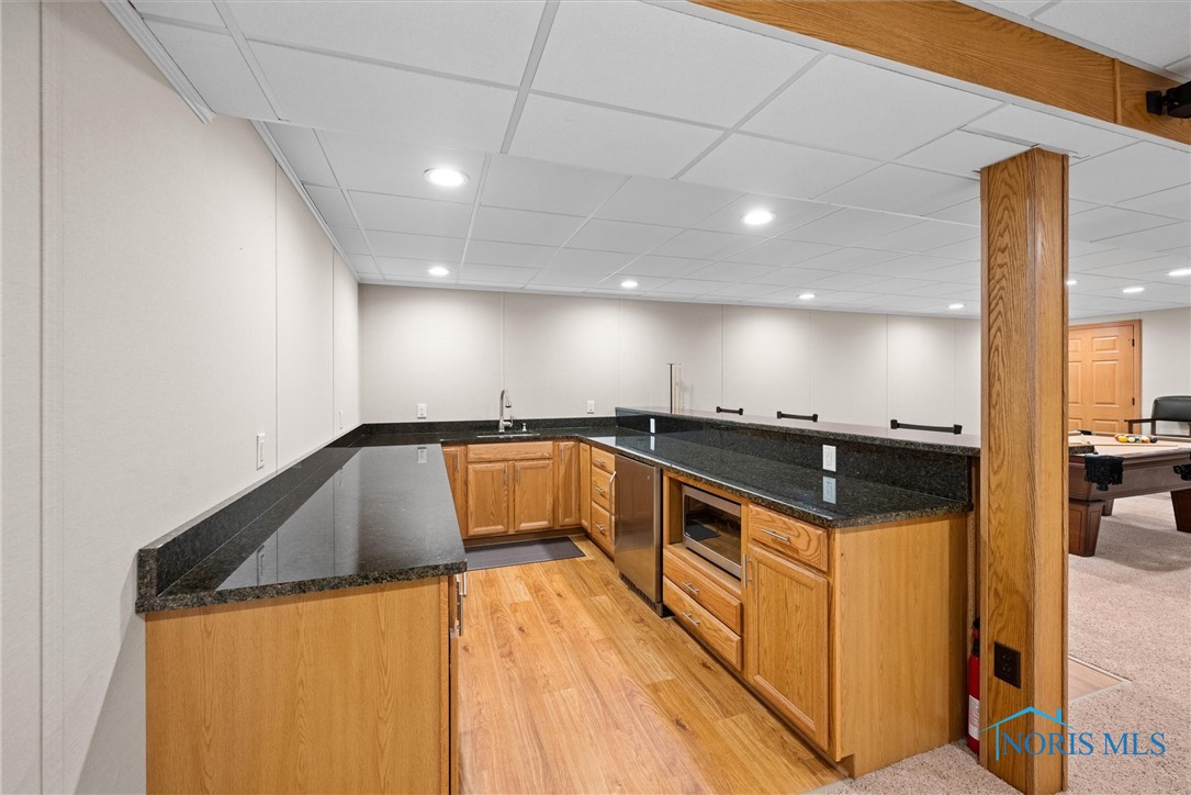 Laminate flooring, granite counters- entertain in style in this basement oasis