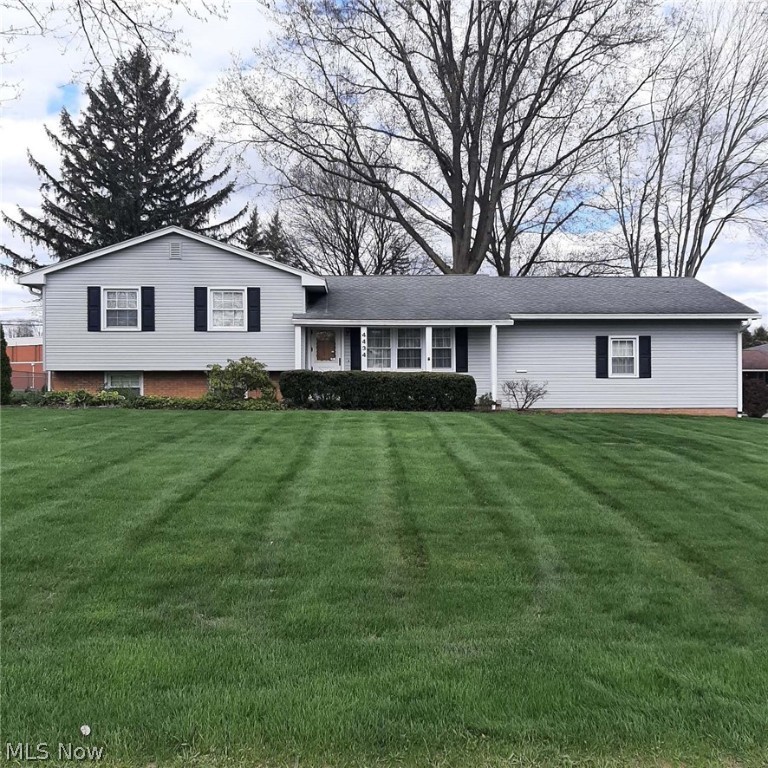 Check out this Austintown beauty located on a large corner lot! It features many exterior improvements, most made within the last 10 years. New gutters with gutter guards keep the water flowing to the oversized 3" X 4" downspouts. The home looks nearly new with the maintenance-free vinyl siding, newer exterior and garage doors, and vinyl replacement windows with muntins for a touch of class. The 2 car garage is oversized with plenty of room on the sides for your storage needs. Inside, you'll enjoy such kitchen conveniences as a built-in microwave, dishwasher and garbage disposal. The main level sports the original hardwood flooring in excellent condition in the large living room and dining room. Step out of the dining room through the sliding patio door and enjoy the sunshine in your very own sunroom. When you're ready to settle in for the night, head to the upper level where you will find the three bedrooms. Under the carpeted rooms, you will find original hardwood flooring to match the main level. Also on this level is a full bath with a walk-in tub. The lower level has yet another full bath, a small room that can be a fourth bedroom or office, and a large family room for more secluded entertainment. The basement level has plenty of room for storage as well as your laundry area and workbench. This is a lot of home for the money. All it needs is a new owner's personal touch!