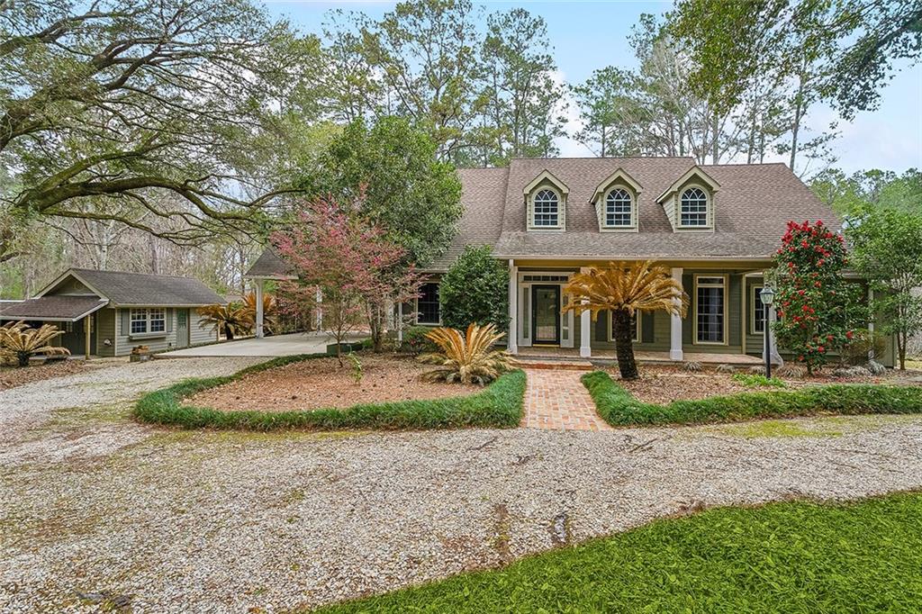 Welcome to your dream retreat nestled among 40 acres of pristine woodlands. This picturesque estate boasts a stunning 2250sqft Acadian home, 6-acres of an 18-acre lake, a stocked bass pond, AND a flourishing blueberry orchard. As you drive down the winding driveway, you'll be captivated by the sounds of nature & the complete privacy of this estate. The 3bd/2bth home offers inviting front & rear porches to enjoy the scenic views. Step inside to discover a spacious interior that seamlessly blends modern comfort with traditional charm. This home is perfect for entertaining, with a well-appointed kitchen featuring solid surface countertops, stainless steel appliances including gas range, custom maple cabinetry, a large breakfast bar, & spacious dining area. The living room features 12ft ceilings, custom built-ins, a high efficiency smart fireplace & nail down wood flooring. Large formal dining room could double as an office with views of the lush surroundings. Escape to the master suite, where you'll find a custom walk-in closet & large ensuite. Additional bedrooms offer ample space for family & guests. Fish, swim, or paddleboard in the tranquil waters of the lake, or cast a line in the stocked pond, take a stroll through the blueberry orchard, or explore many of the other trails and enjoy the beauty of nature. Whether you're seeking a peaceful retreat, a place to entertain friends and family, or an outdoor enthusiast's paradise, this property offers it all! Don't miss your chance to own this rare gem where the ultimate in privacy and seclusion is married with the convenience of being just 12 miles (17 mins to Downtown Covington). Property also includes 22'x12' shed with 12'x22' open storage, and a 16'x25' pole barn with attached 25'x8' lean-to. 2 tankless water heaters, High efficiency Trane HVAC, High efficiency heater, Canadian Cedar exterior, 40yr roof timberline ultra shingles. Schedule your private tour today and experience the magic of this extraordinary estate!