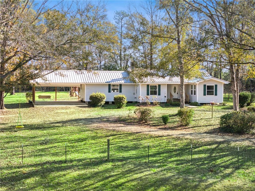 Set on 6 gently rolling acres, this enchanting country cottage offers the perfect blend of privacy and convenience. The property features a serene pond, mature hardwoods scattered across the landscape, and an expansive, mostly cleared lot that invites you to enjoy the natural beauty that surrounds you. The home has been thoughtfully updated to include a spacious dining room, ideal for family gatherings or intimate dinners, as well as a new carport and a charming back porch that extends the living space to the outdoors. The property is fenced, making it an ideal retreat for animal lovers, with ample space for grazing or play. A standout feature is the impressive 42x40 shop, offering plenty of room for storage, hobbies, or projects. Additionally, there are two covered buildings designed for livestock or other animals, ensuring that this property is as functional as it is picturesque. With its perfect mix of luxury, convenience, and rural charm, this property is an extraordinary place to call home.