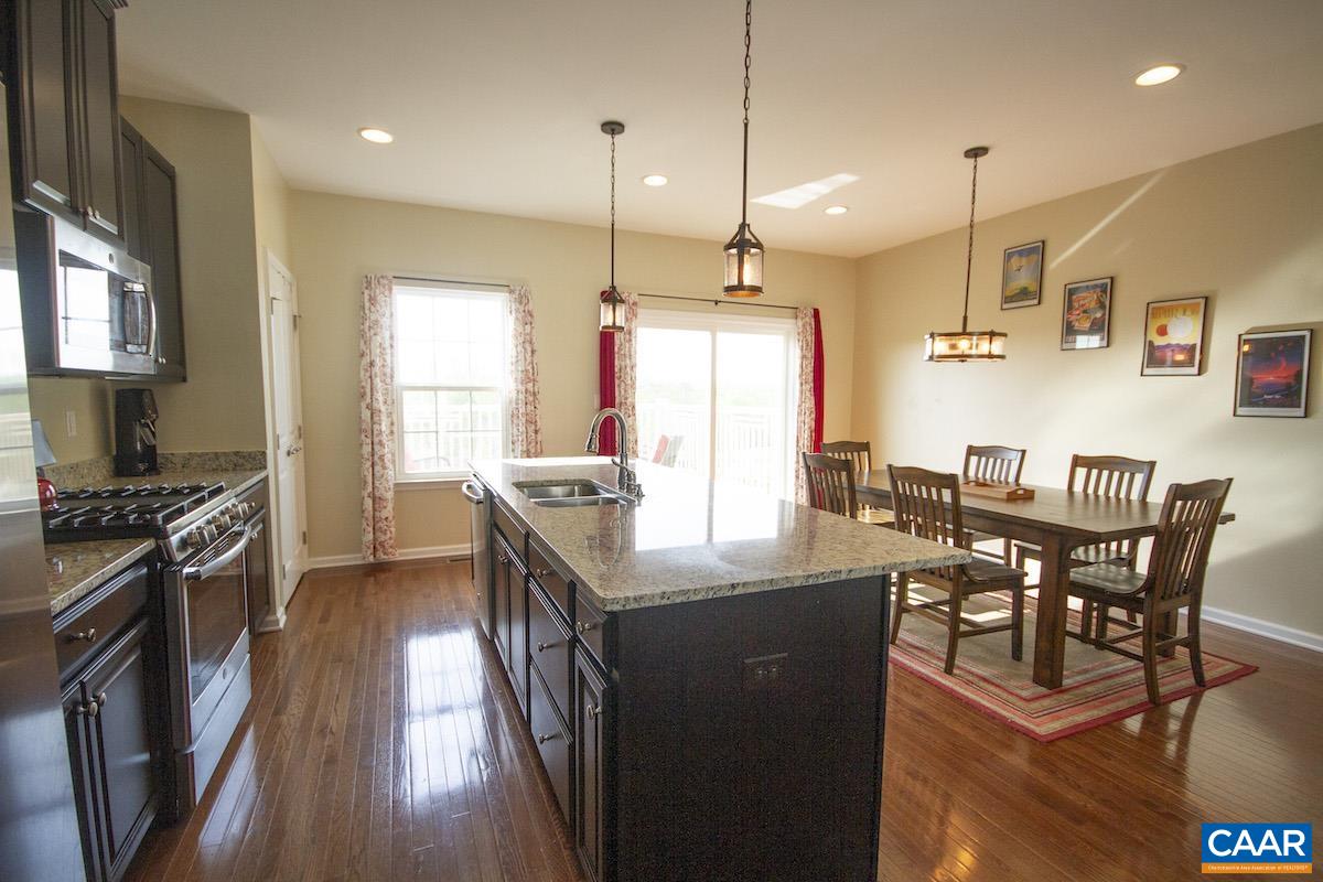Enjoy the sunrise over the mountains from your beautiful new home! The floorplan of this lovely townhouse is perfectly flexible for any lifestyle. The main level of the home has a wide open floorplan with hardwood floors. A large kitchen made for a home chef with oversized island with tons of cabinet and counter space. The spacious dining area fits a large table for entertaining. All of this opens to the living room creating a comfortable space with tons of natural light! Walk out onto the back deck to grill & lounge while enjoying your mountain view. Go upstairs to the bedroom level to find a wonderful master bedroom suite with a big walk-in closet & attached bath. The additional two bedrooms, full bath, & laundry complete the upstairs. Don't miss the pull down to access the attic storage space! The downstairs has a huge multi-purpose room perfect for a rec room or office. You can add a barn door to create another bedroom space. The lower level walks out to the back lawn & additional common space which is perfect for your pup. The neighborhood has a trail to the river & playgrounds.  Walking distance from Rivanna Station (NGIC & DIA) & minutes to the UVA Research Park, Target, and the Hollymead Town Center shopping.
