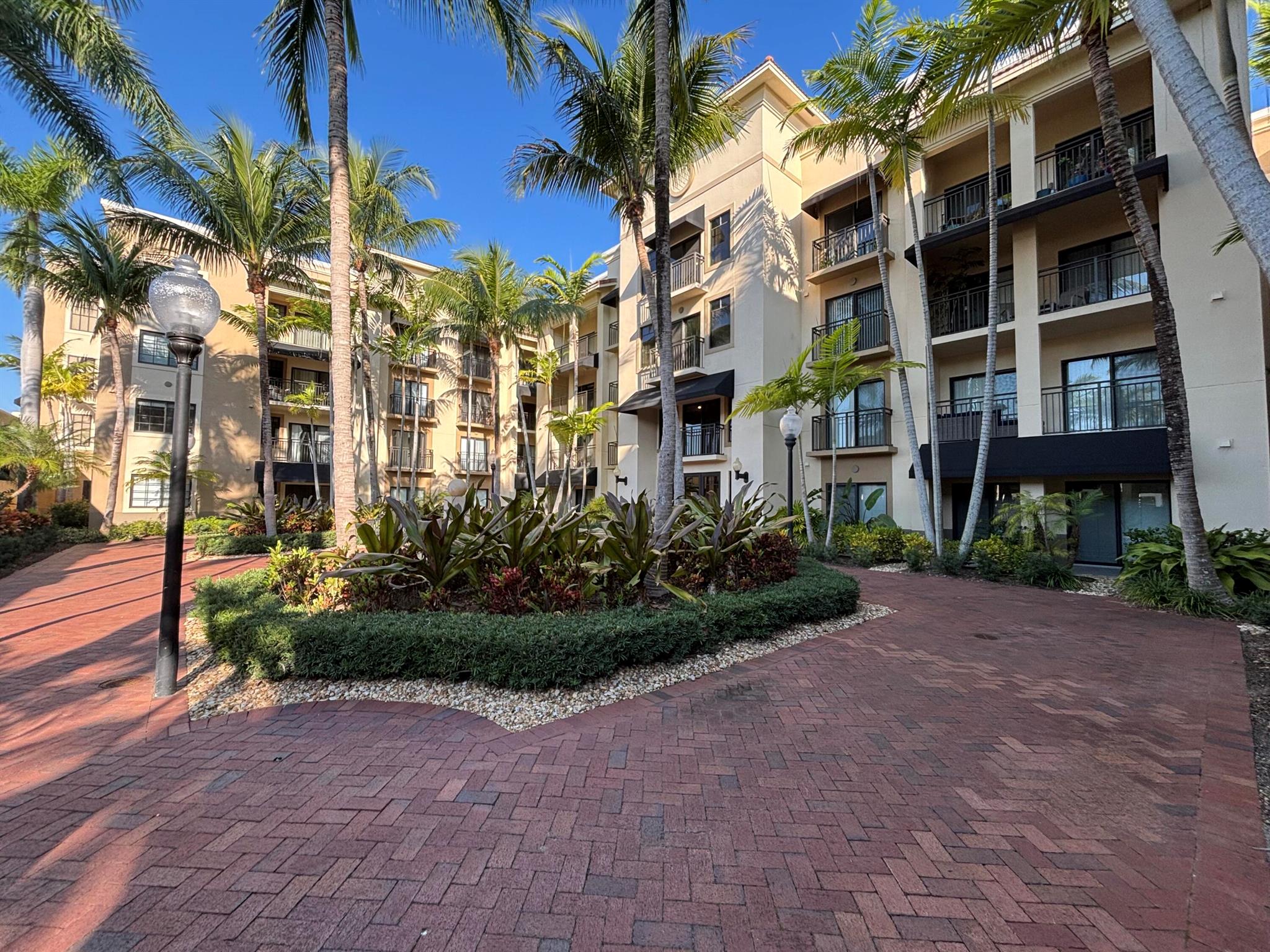 Rarely available 1st floor 3 BEDROOM end unit Move-in Ready with brand new quartz counter tops, kitchen pantry, refrigerator, APEC UV-PH water system, Light fixtures, Fans, HVAC and flooring. NO CARPET! Enjoy easy living lifestyle with your first floor location by skipping the need to take an elevator/stairs and long hallways! This home includes a large covered private patio overlooking lushly landscaped courtyard and  2 garage parking spots.  Amenities include gym, clubhouse, pool, spa, tennis and a lakefront dog walk. Water & Sewer included in HOA fee. Impact windows & doors. Short walk to shops, dining, entertainment & Fresh Market. Furniture negotiable. Quick access to Beach, Golf, PGA National resort &  I95 *Owner-Agent.