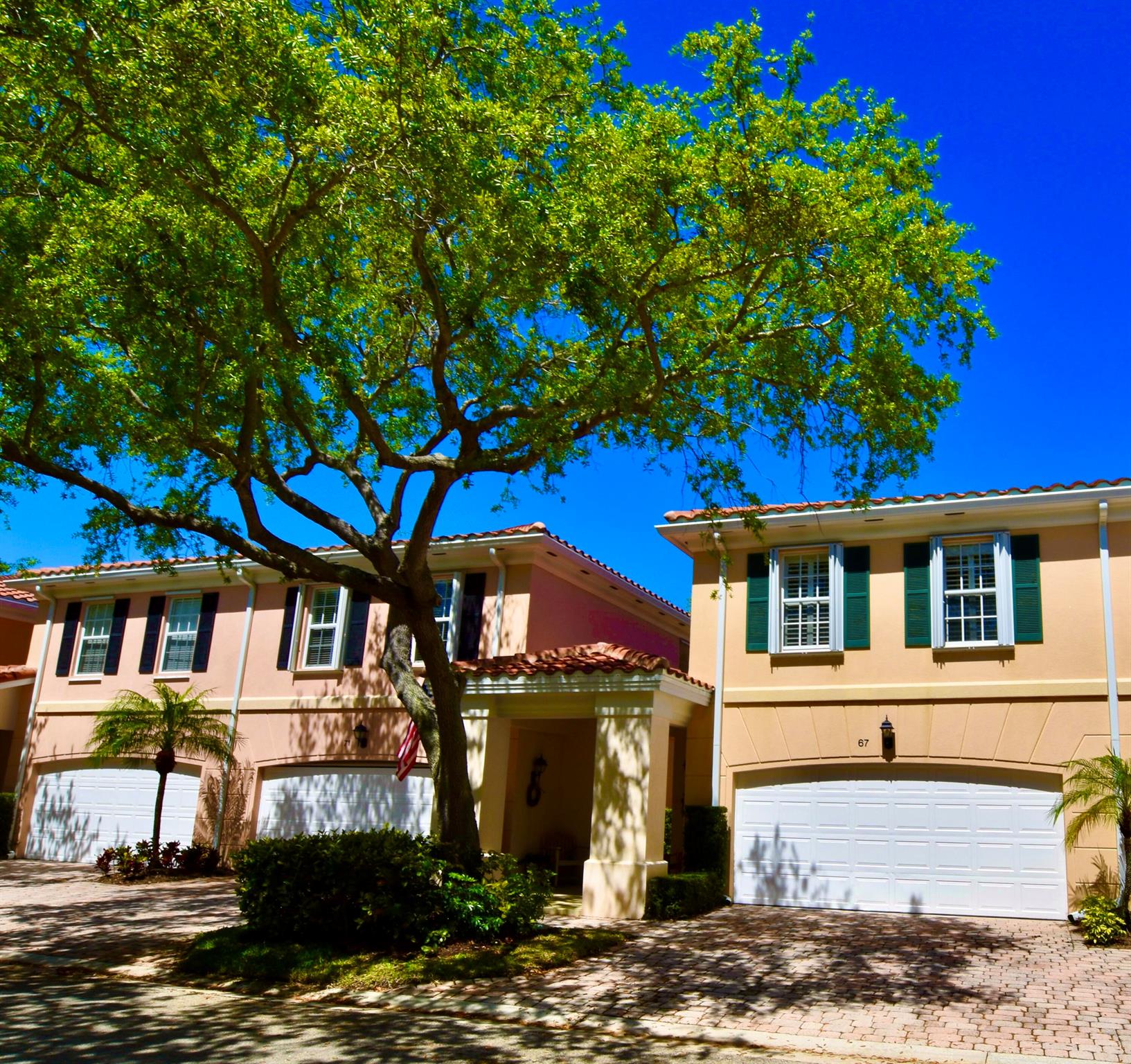 Divosta built, fully concrete constructed, 3BR, 2.5Bath Townhome in an oak lined, private, well managed community.  Townhome situated on premium lot that backs to parking lot. Unit located 4 units from community pool.   Interior features include hardwood flooring, new (never used) stainless steel refrigerator, microwave, dishwasher, garbage disposal, and kitchen faucet.  Open floor plan downstairs. Upstairs- laundry, primary bedroom with ensuite primary bathroom and walk-in closet and plantation shutters.  Screen and paved back patio and screen enclosed back porch w/ vinyl windows/ability to A/C the screed porch. Accordion hurricane shuttler, impact glass sliders and tile roof replaced 2023. A/C new 2023.  Garage door opener replaced 2023. Zoned for A rated Jupiter Schools.Watch video