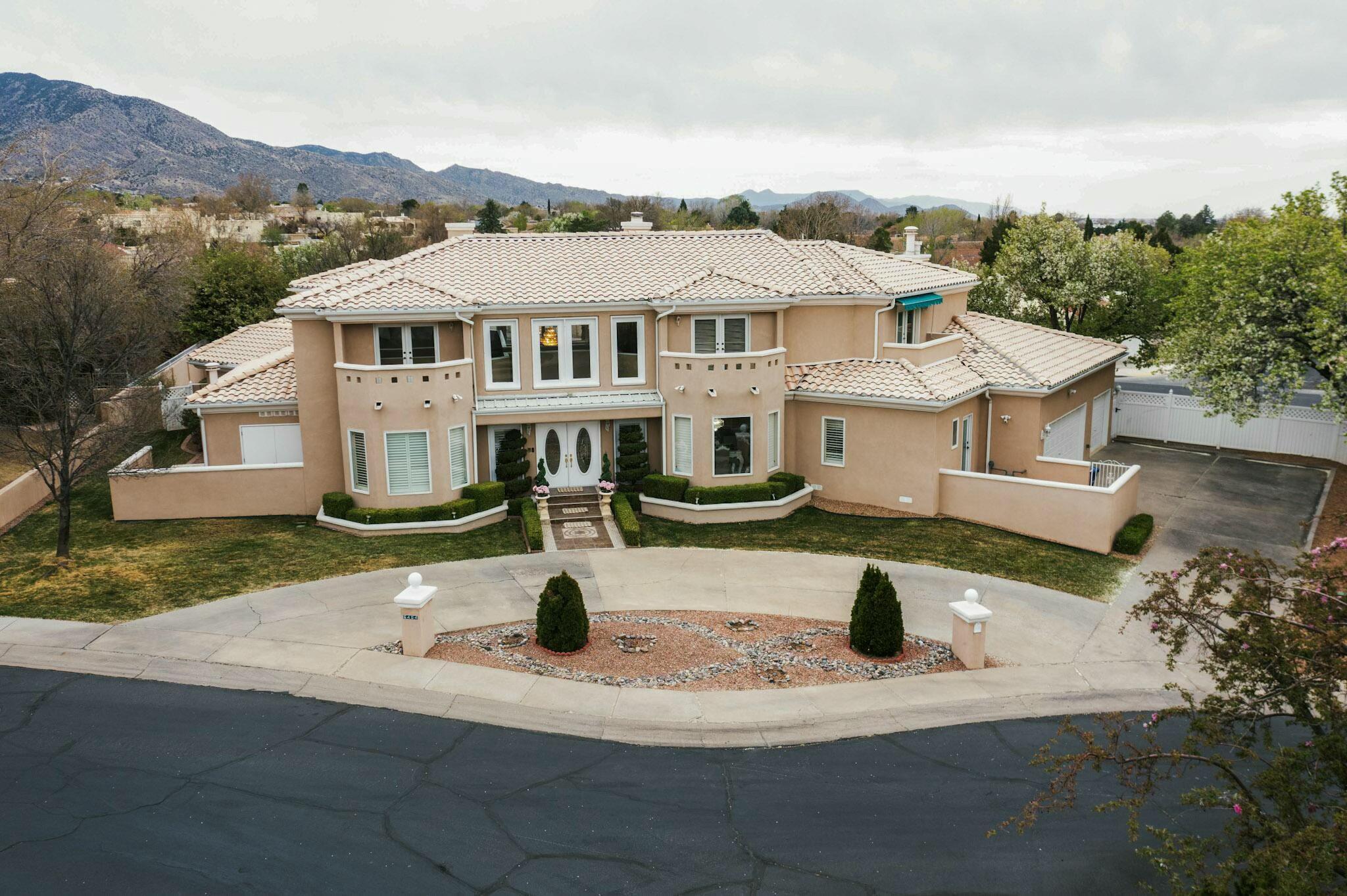 Discover elevated living in the sought-after Tanoan community. This spacious estate offers 7 bedrooms, 8 bathrooms, and a 3-car garage. Thoughtfully designed for both comfort and functionality, the open floorplan is filled with natural light and includes three generous living areas anchored by two impressive fireplaces. The kitchen features granite countertops, a large island, and quality appliances, making it ideal for everyday meals or hosting guests. The primary suite provides a serene retreat with a jetted tub, steam shower, and walk-in closets. Step outside to a peaceful backyard setting with a sparkling pool, hot tub, vibrant landscaping, and a covered patio--perfect for entertaining or relaxing.