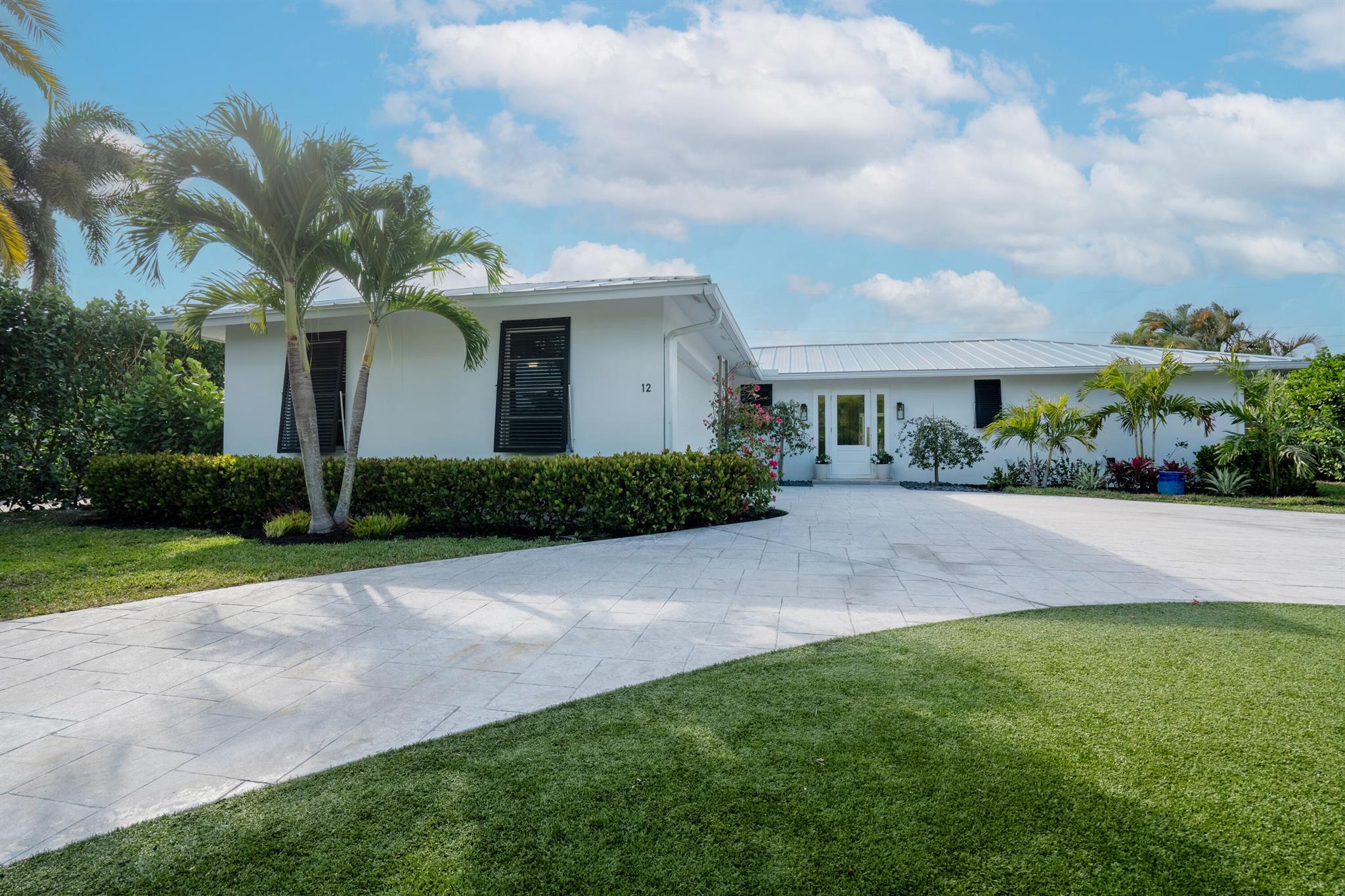 Welcome to Hitching Post Circle in the prestigious Turtle Creek Golf Club community. This property outshines any other Hunt Club interior lot, situated on the curve of Hitching Post Circle and Saddleback Road - home to multi million dollar waterfront estates. Every sunrise and sunset is visible from the entry glass door looking east with a view of the Loxahatchee River. From the generous front yard, oversized circular drive, turf grass, mature canary palms. coconut palms, fox tail palms, begonias and 12'-15' high clusia hedges adds beauty and incredible privacy. NEW white metal roof 2024, pure white exterior paint, NEW hurricane rated flush garage door. NEW impact 3/4 lite front entry door with full side lites adorned with a beautiful brushed gold Emtek entry handle set. 3 bed, 2 bath, 2 car garage, CBS construction with a pool, large covered patio, turf grass in the front, back and side yard and landscaping. Renovation completed 2025 NEW thin shaker natural wood Pro Craft cabinets, Samsung Bespoke appliances, GE wall ovens, white quartz counter tops, rose gold hardware - cabinet pulls and knobs. Bathrooms fully renovated. NEW air ducts and air handler 2024. Upgraded metal roof to aluminum was an additional $5K. Oversized grey concrete look porcelain tile throughout. NEW one panel interior shaker doors with Emtek handle sets.