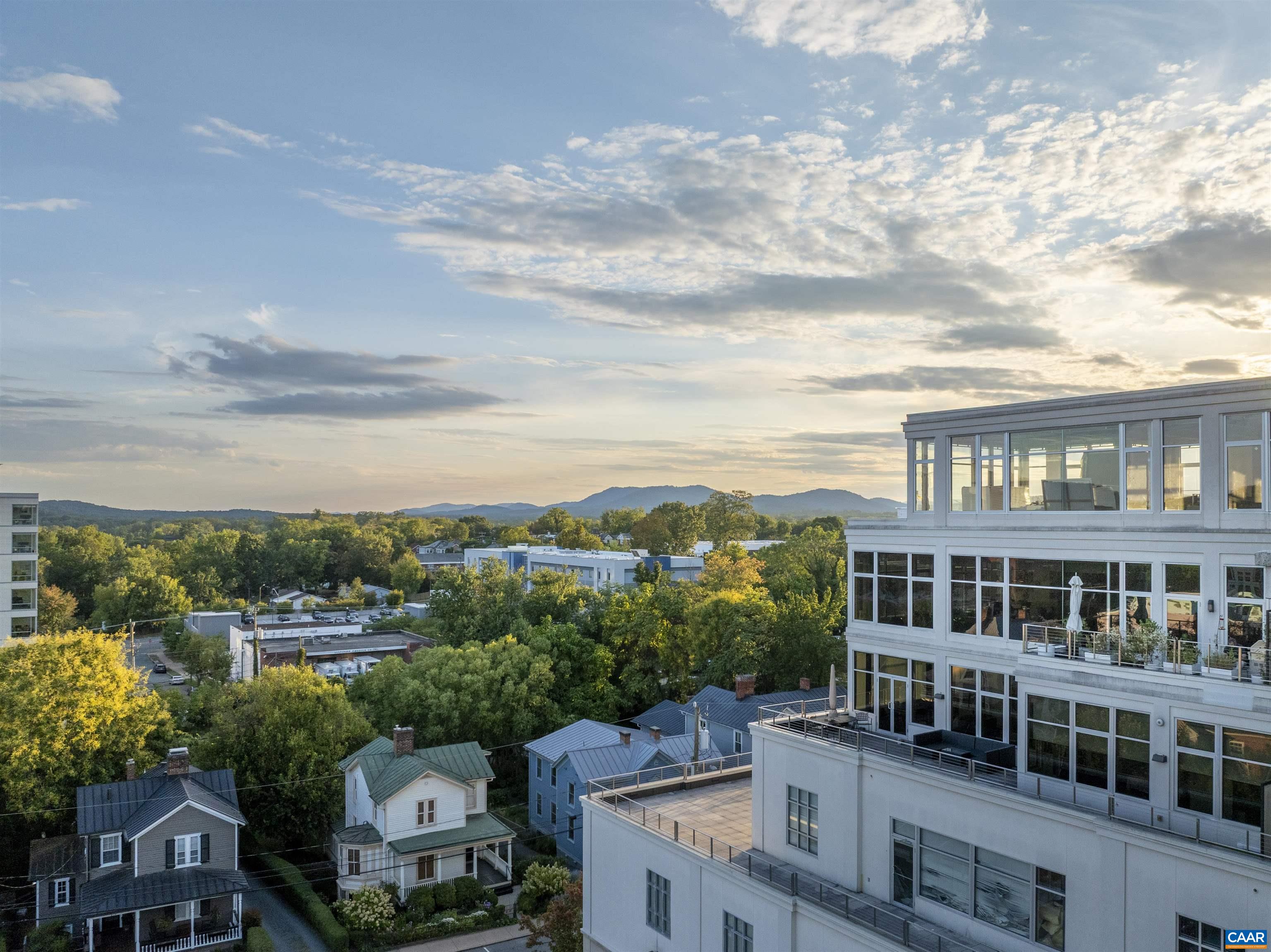 This modern home is an understated jewel offering picturesque views of the city and the surrounding Blue Ridge Mountains from three sides.  An expansive open floor plan is an entertainer’s dream.  The gourmet kitchen features high-end Thermador appliances including an induction cooktop, oven, microwave, fridge, and dual-zone wine fridge.  The large, sleek island provides plenty of space for preparing a meal while conversing with your guests. Enjoy the meal in the dining room area or on the private terrace.   A nearby pantry provides even more space to keep small appliances out of sight and store pantry staples.  Flanking either side of the expansive great room is a large bedroom with en-suite bath.  The primary suite features a sitting area, custom walk-in closet, and ensuite bathroom with floating vanity, deep soaking tub and zero-entry shower area.  The second bedroom also has a custom walk-in closet and large ensuite bathroom with dual vanities.  The shades and lights throughout can be controlled manually or using voice or app commands to set the desired mood for your home.   A large laundry room offers additional storage.  Deeded garage parking and EV charger included.
