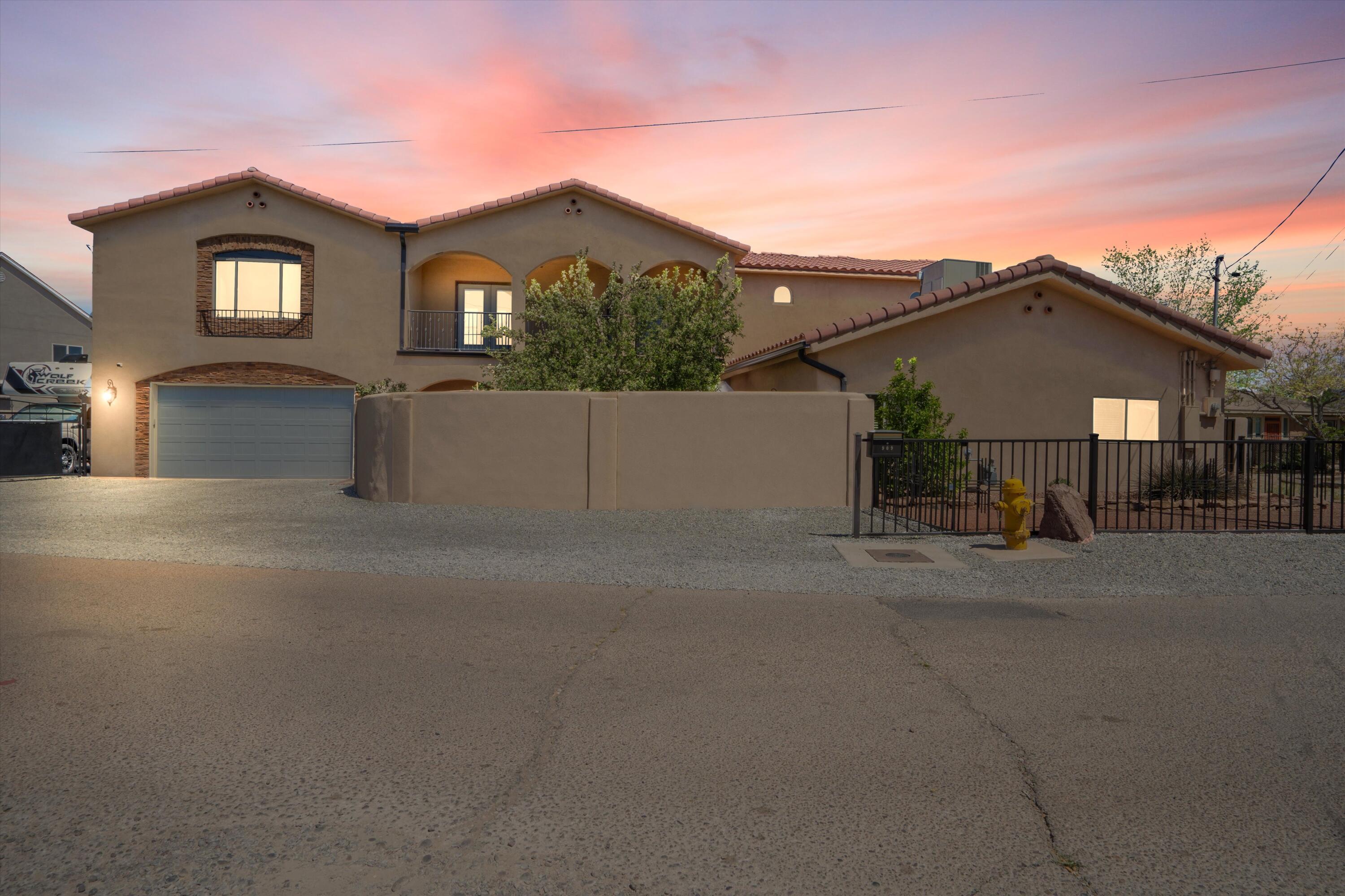 Discover an extraordinary blend of historic charm and contemporary elegance added in 2018 in the heart of Downtown Albuquerque. This one-of-a-kind property is a must-see. Step into a private, gated courtyard featuring lush grass and a covered patio--perfect for relaxing or entertaining. Inside, you're welcomed by a stunning open-concept Great Room with a cozy fireplace, seamlessly flowing into a beautifully updated custom chef's kitchen. The kitchen is outfitted with granite countertops, a large center island, and stylish cabinetry, creating the perfect space for gatherings and culinary creativity. Step down into the formal dining room and discover a second living area along with two lower-level bedrooms--all part of the original adobe home built in the early 1900s.